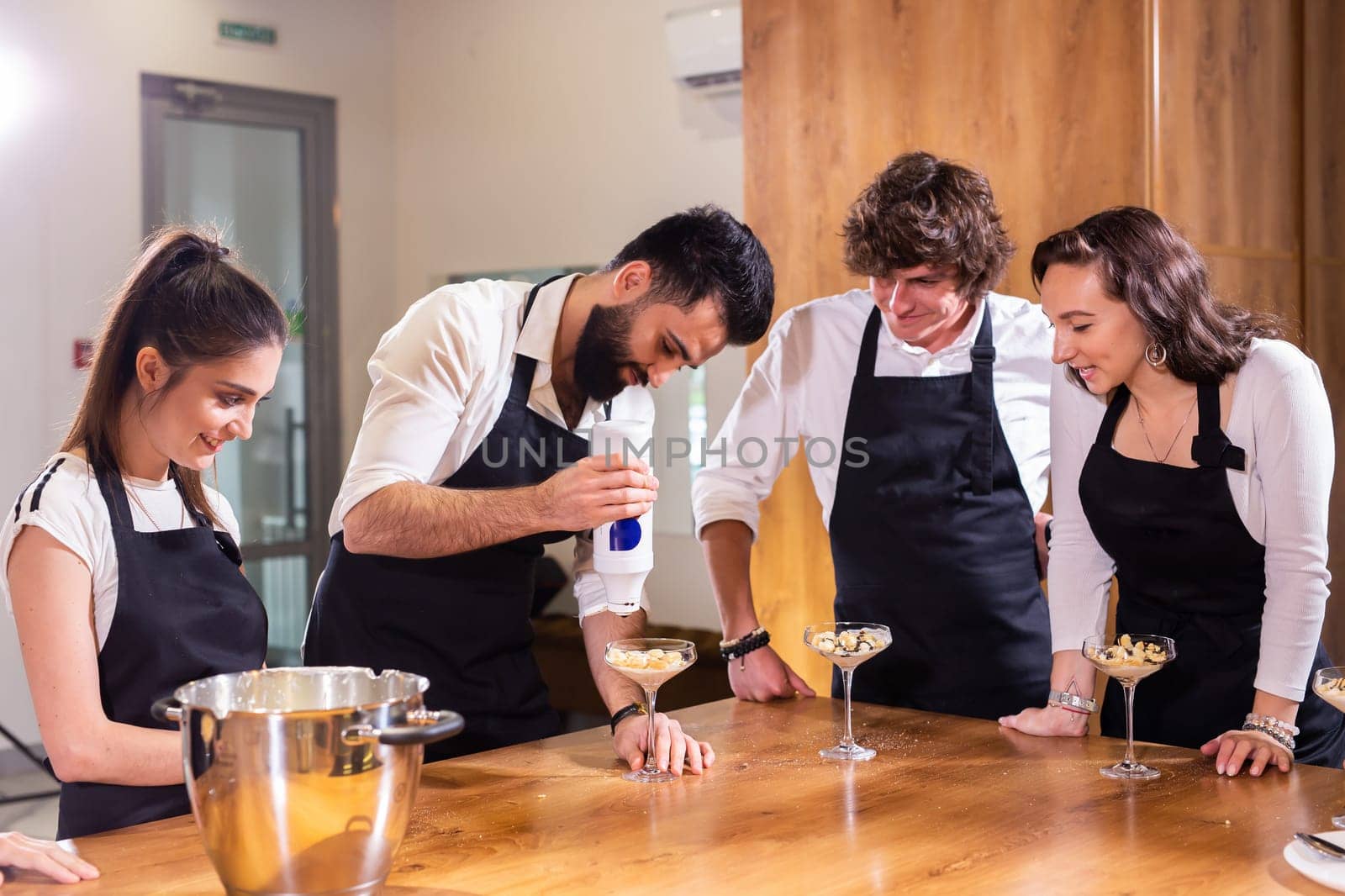 Chef teaching trainees how to make ice cream. Cooking tasty ice cream dessert made from chocolate and vanilla in glass bowl by Satura86