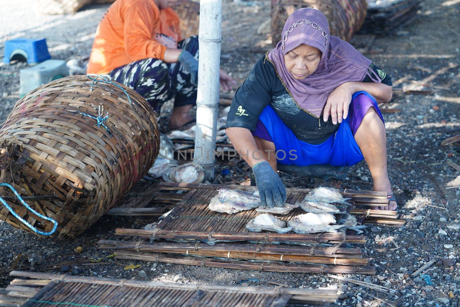 May 13, 2023. The preparation to dry the salted fish on a bamboo tray in Gresik, Indonesia. Street videography.