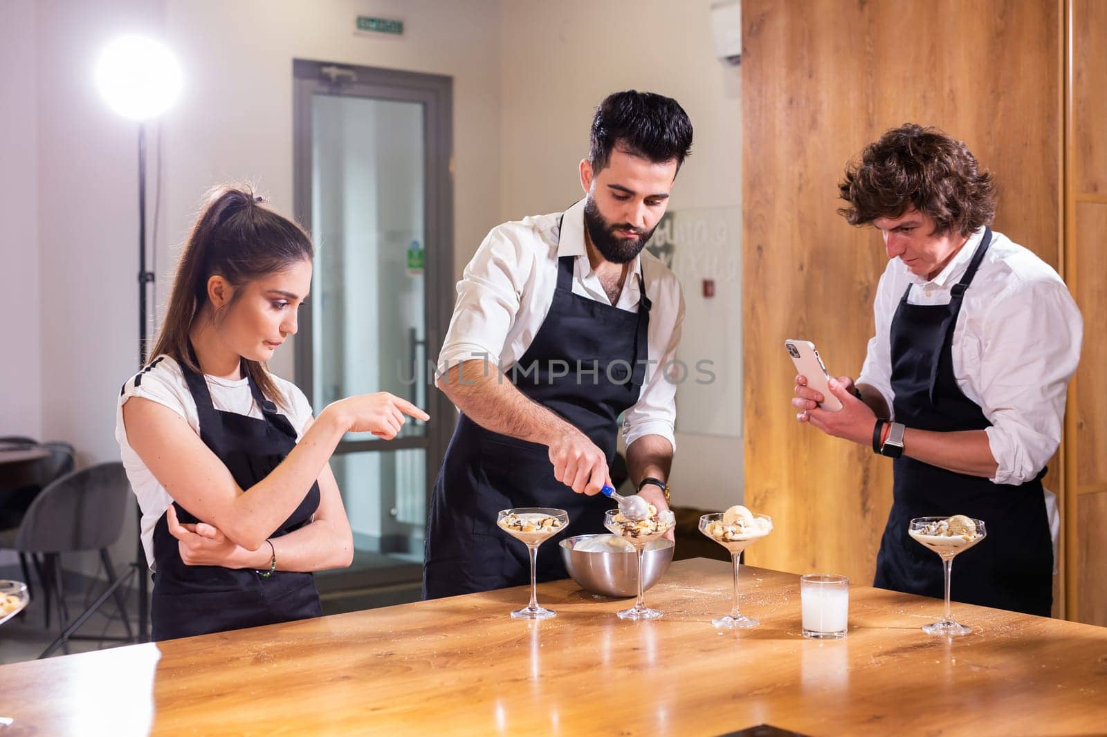 Chef teaching trainees how to make ice cream. Cooking tasty ice cream dessert made from chocolate and vanilla in glass bowl by Satura86