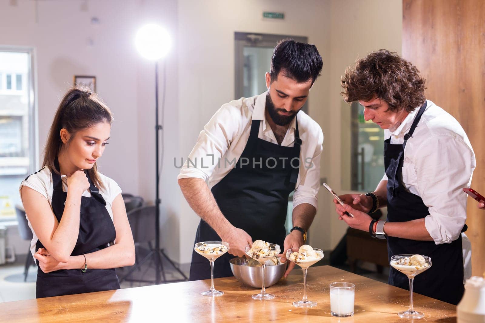 Chef teaching trainees how to make ice cream. Cooking tasty ice cream dessert made from chocolate and vanilla in glass bowl by Satura86