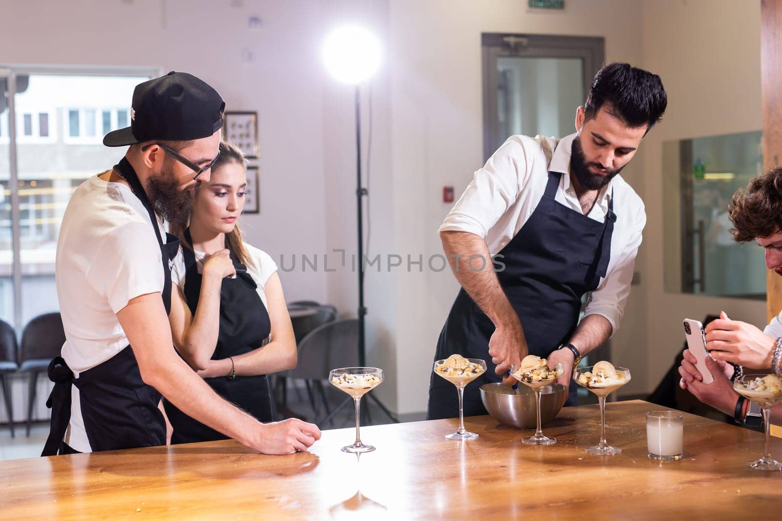 Chef teaching trainees how to make ice cream. Cooking tasty ice cream dessert made from chocolate and vanilla in glass bowl by Satura86