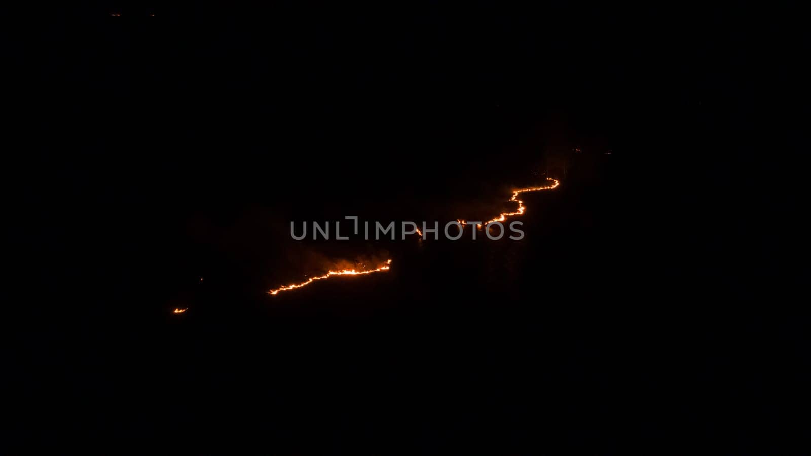 Night fire in the forest with fire and smoke.Epic aerial photo of a smoking wild flame.A blazing,glowing fire at night.Forest fires.Dry grass is burning. climate change,ecology.Line fire in the dark. by YevgeniySam