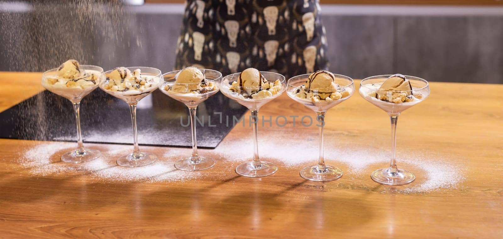 Tasty ice cream dessert made from chocolate and strawberry flavors with nuts and waffle cracker in glass bowl