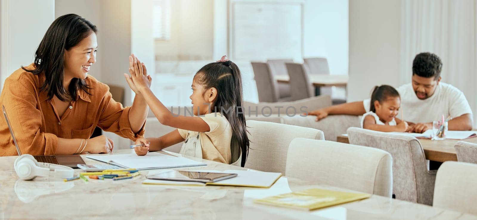 High five, homework and parents with support for children, motivation and goal in education in their house. Happy, excited and girl learning, studying and writing school work with her mom for success.