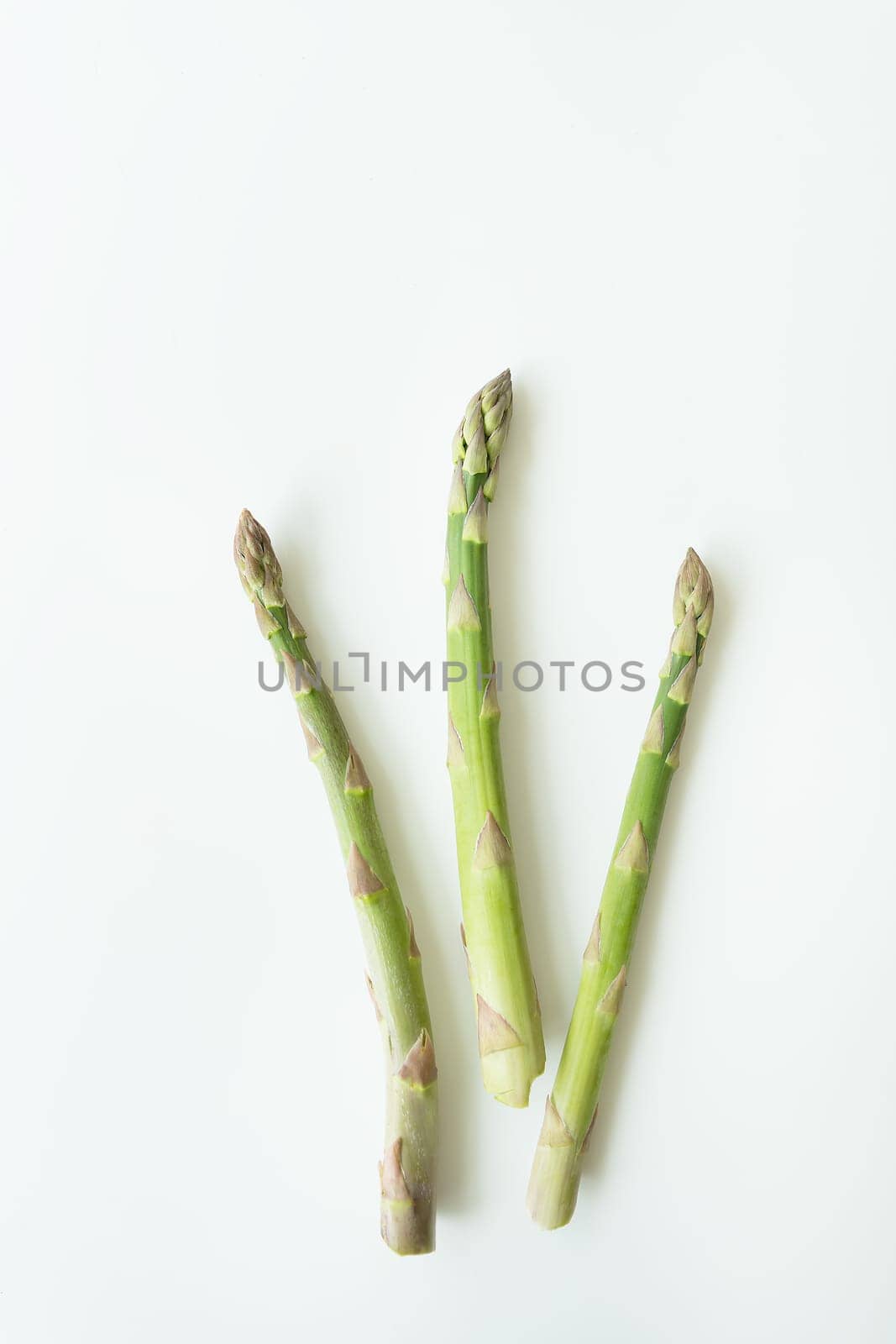 Fresh sliced asparagus on a white background. View from above. Vegan healthy food. Vertical photo
