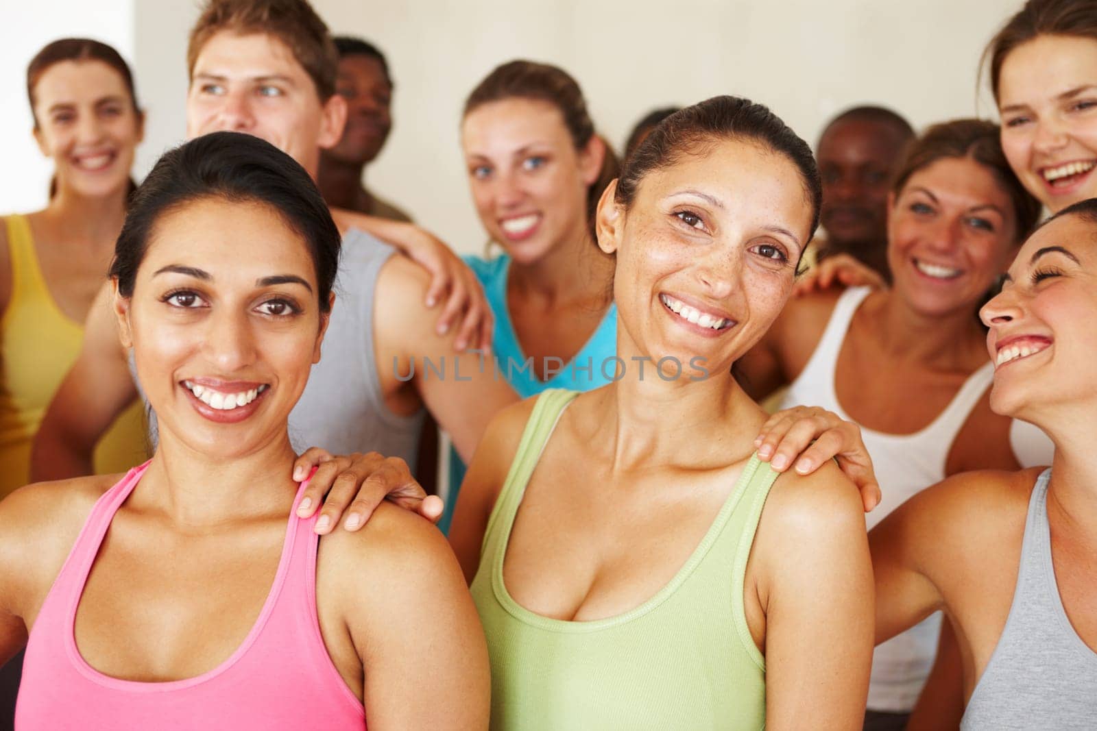 Keeping in shape makes them happy. Portrait of a a group of yoga enthusiasts standing in a yoga studio