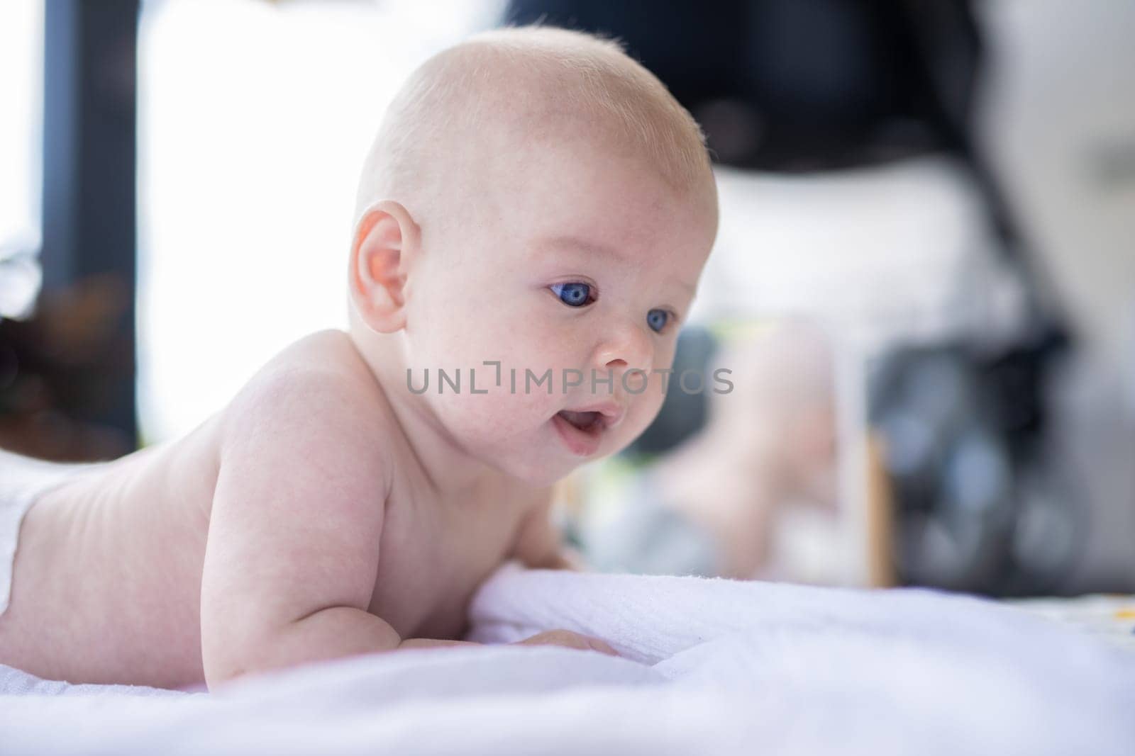 Cute caucasian baby boy lying on stomach