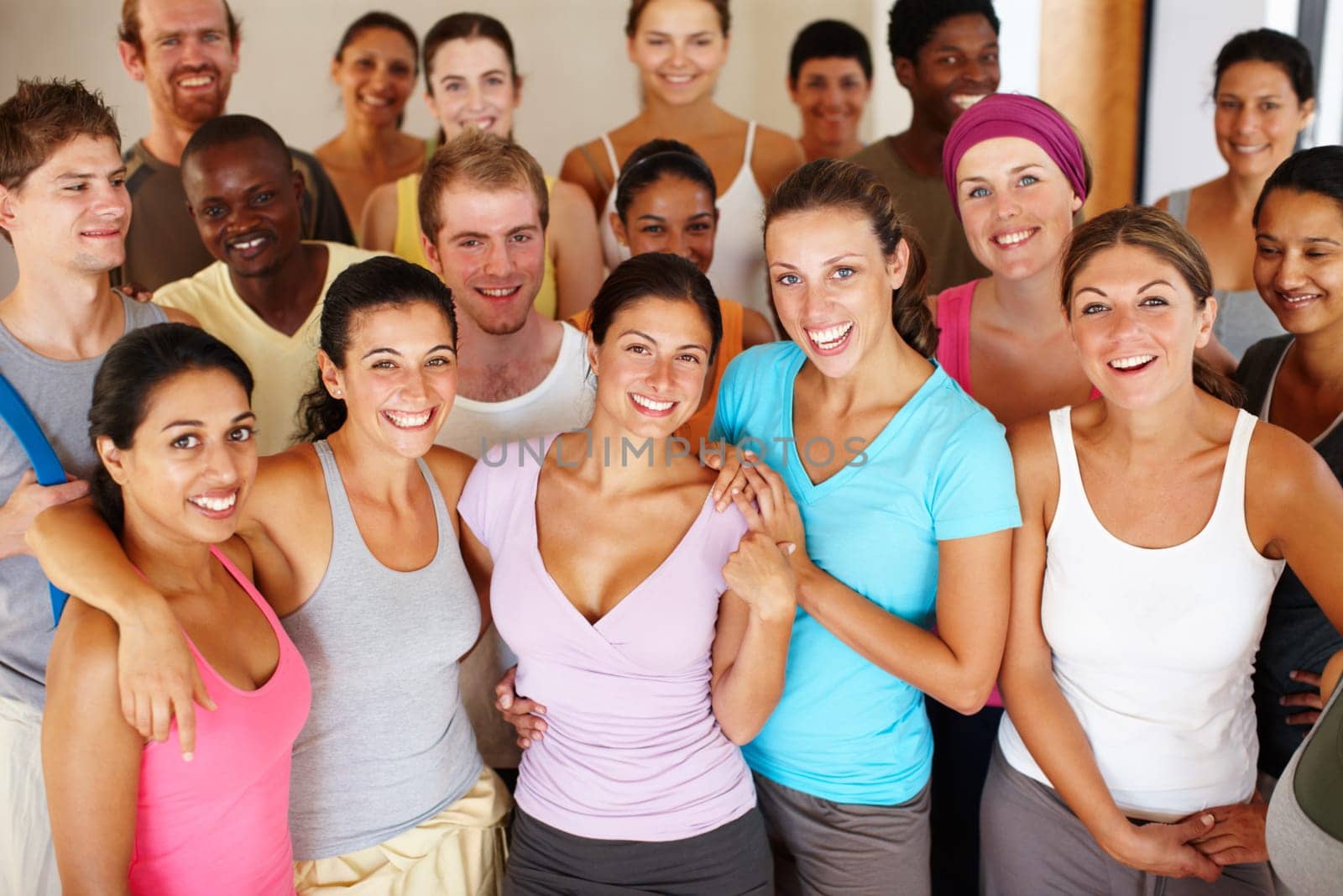 Smiling in the yoga class. Portrait of a a group of yoga enthusiasts standing in a yoga studio