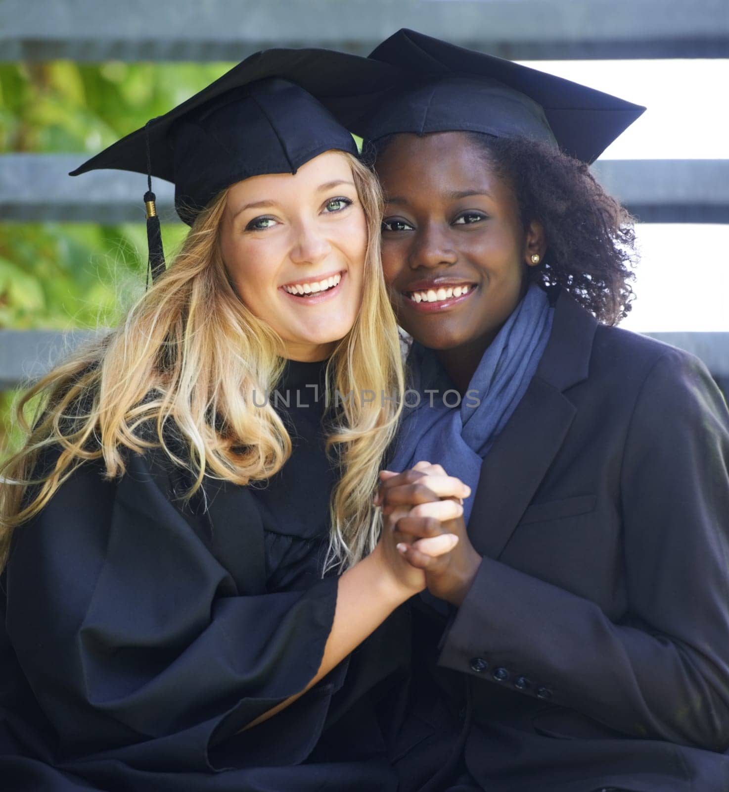 Portrait, graduation and women university friends holding hands on campus together as graduate students. Happy, smile and education with a female college student and her friend celebrating graduating by YuriArcurs