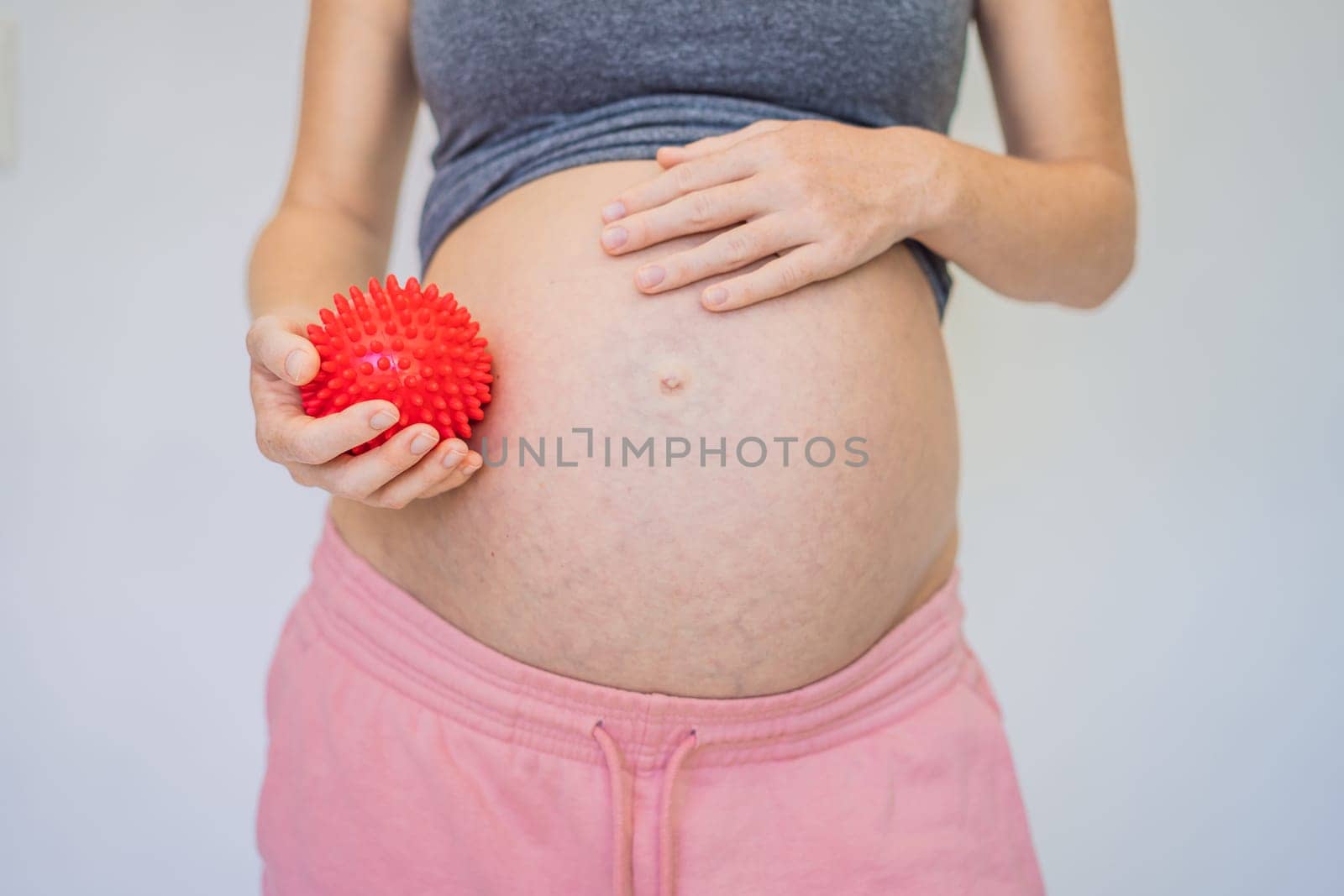 Self-massage with a massager for a pregnant woman.