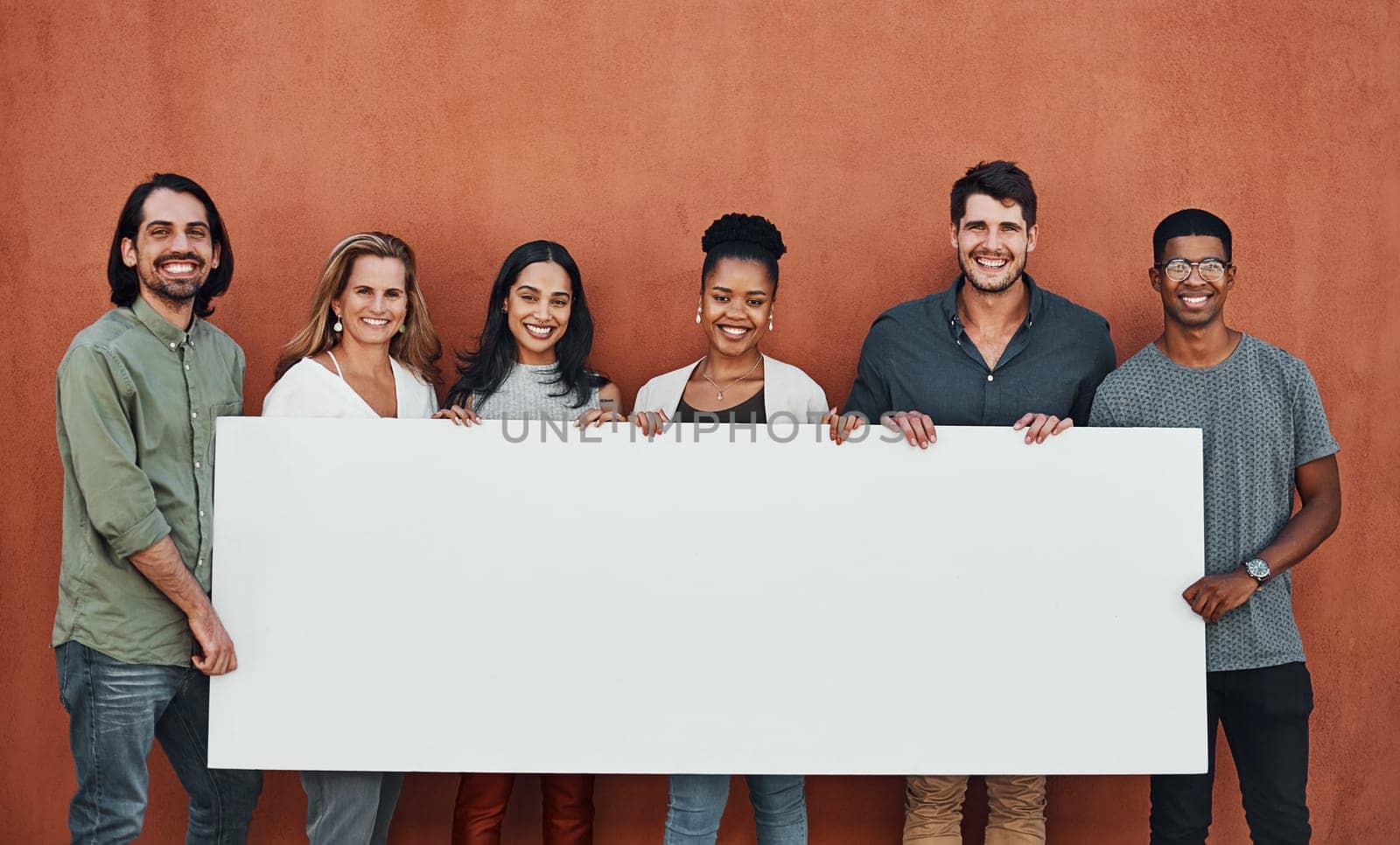 Is this the winning cheque. Cropped portrait of a diverse group of businesspeople standing together and holding a sign while outside. by YuriArcurs