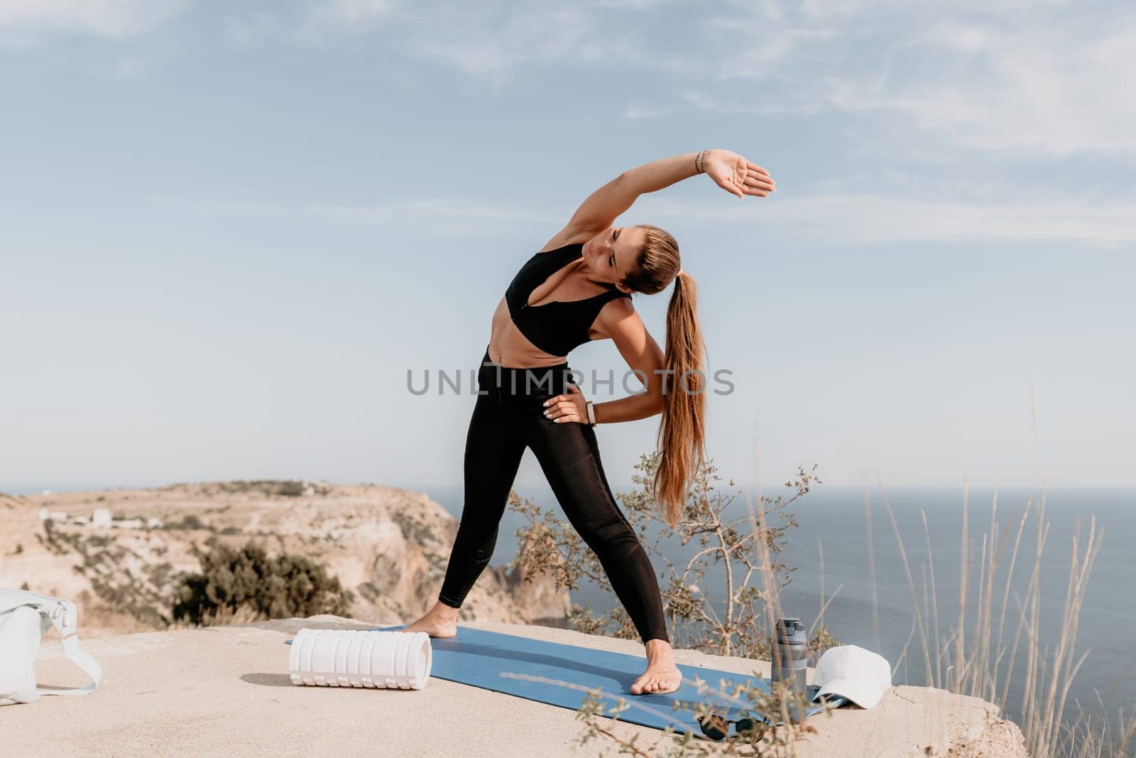 Fitness woman sea. Outdoor workout with fitness rubber bands in park over beach. Female fitness pilates yoga routine concept. Healthy lifestyle. Happy fit woman exercising with rubber band in park