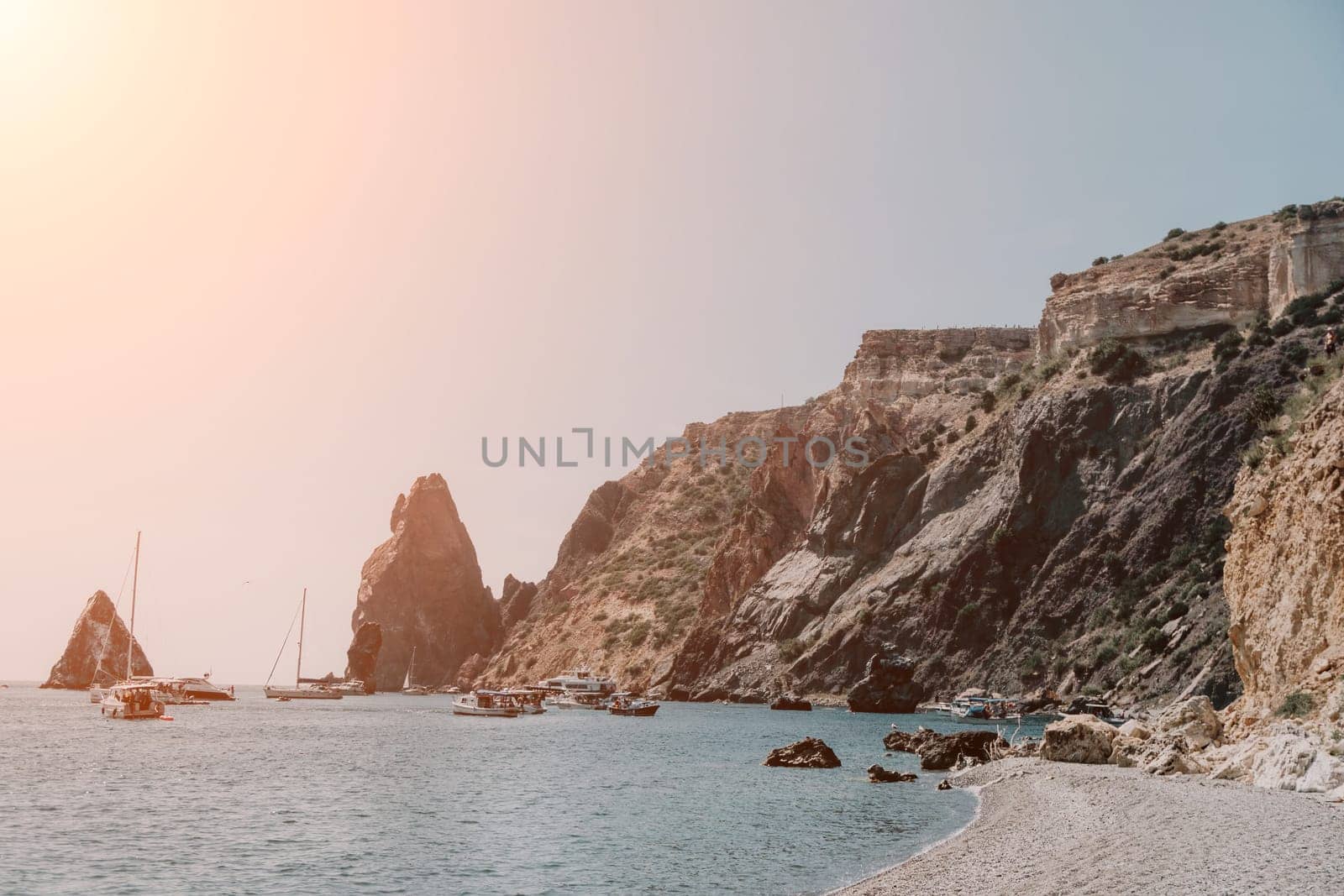 calm azure sea and volcanic rocky shores. Small waves on water surface in motion blur. Nature summer ocean sea beach background. Nobody. Holiday, vacation and travel concept by panophotograph