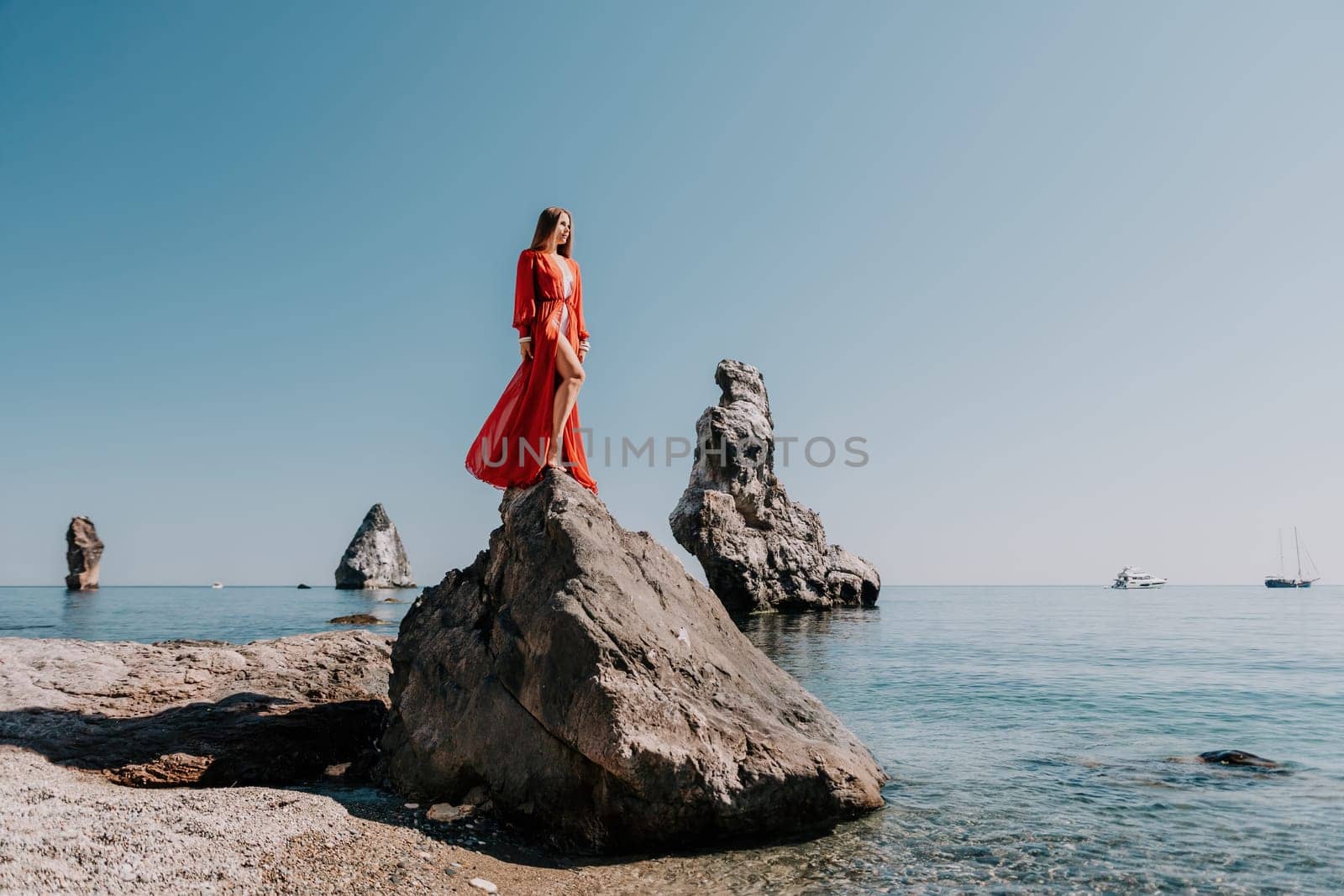 Woman travel sea. Happy tourist taking picture outdoors for memories. Woman traveler looks at the edge of the cliff on the sea bay of mountains, sharing travel adventure journey.