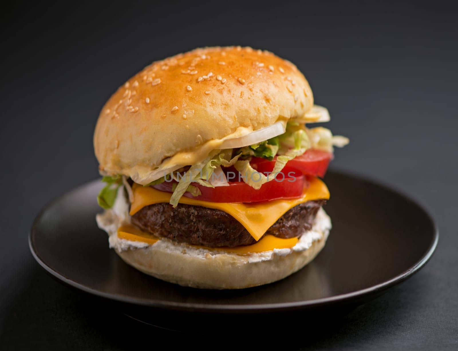 Big tasty burger with beef cutlet on a black background by aprilphoto