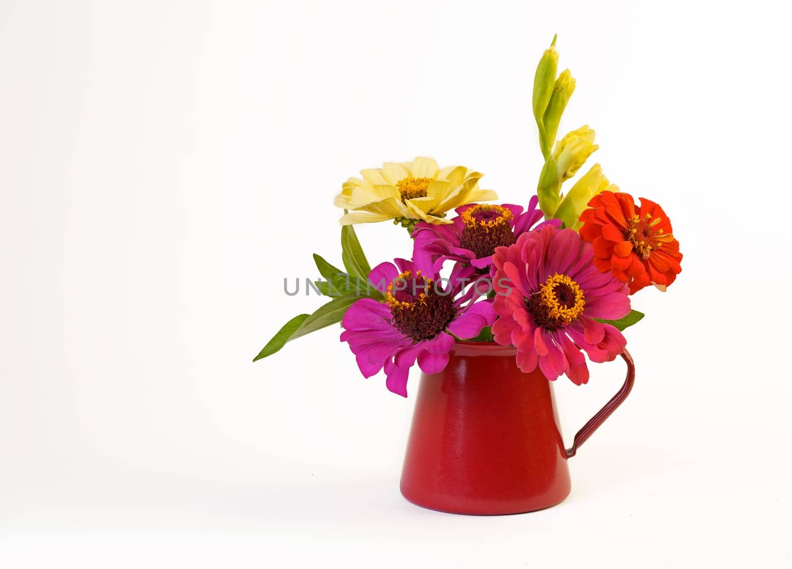 small bouquet of summer flowers in a red vase on a white background