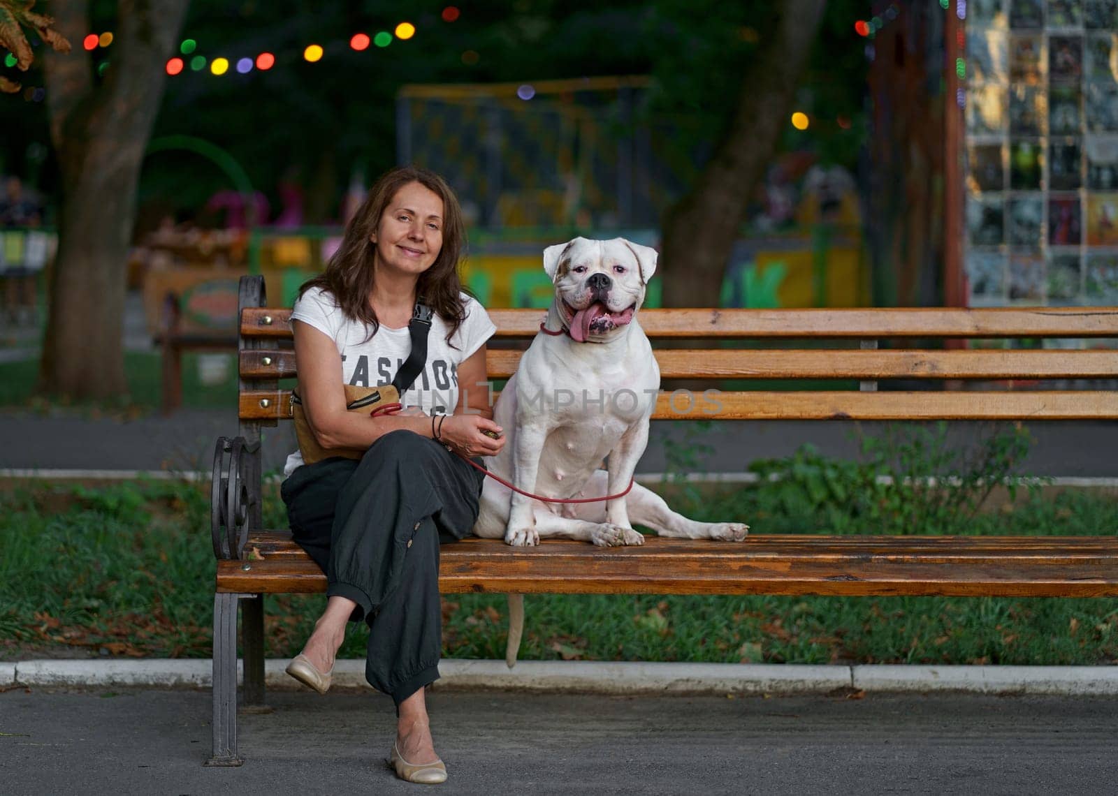 woman sitting on a park bench with her dog