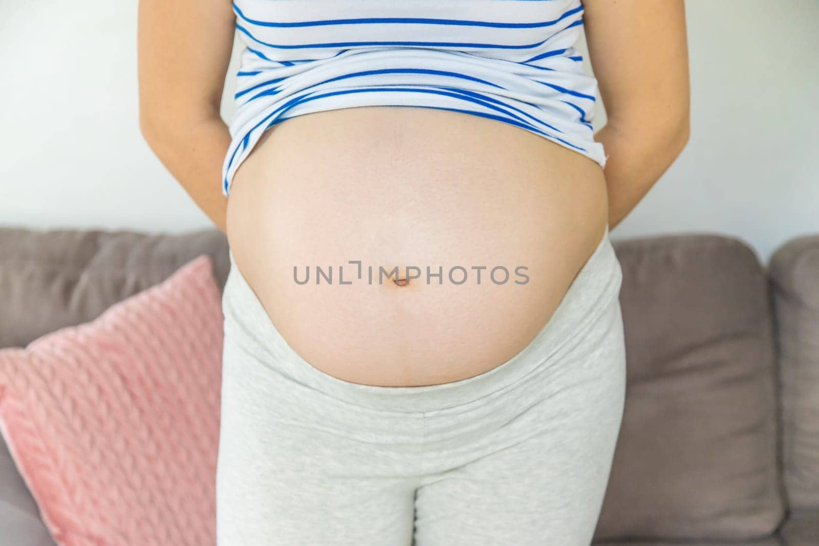 Pregnant woman hugs her belly. Selective focus. Cute.