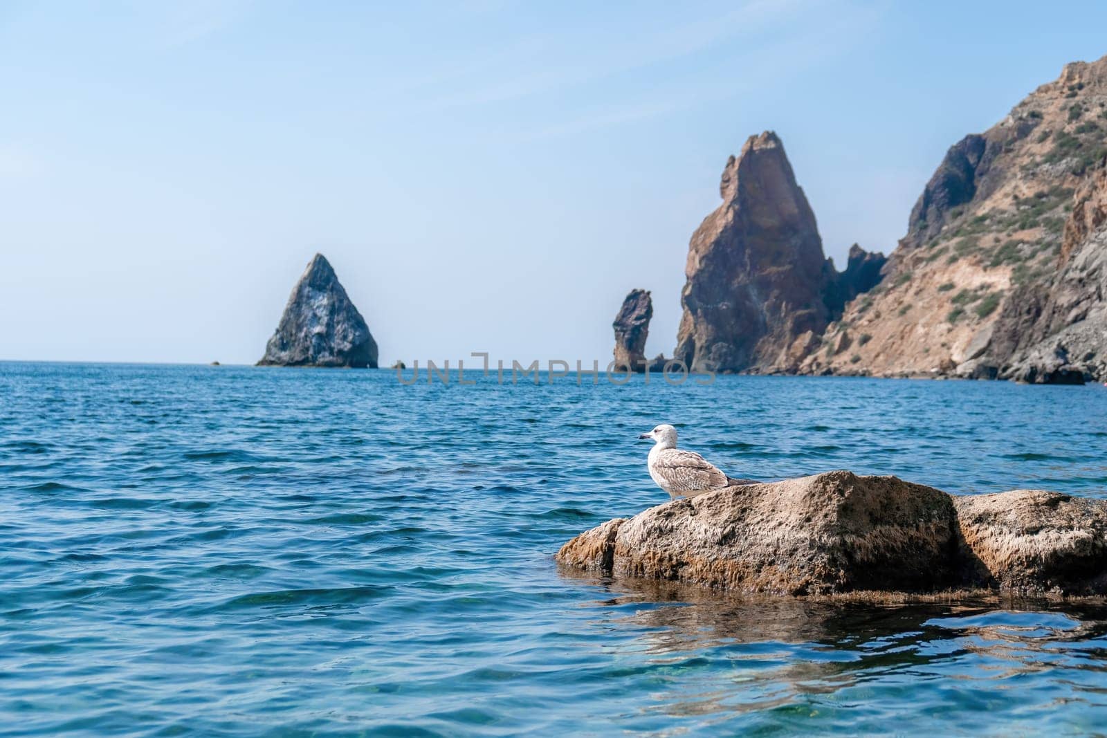 calm azure sea and volcanic rocky shores. Small waves on water surface in motion blur. Nature summer ocean sea beach background. Nobody. Holiday, vacation and travel concept by panophotograph