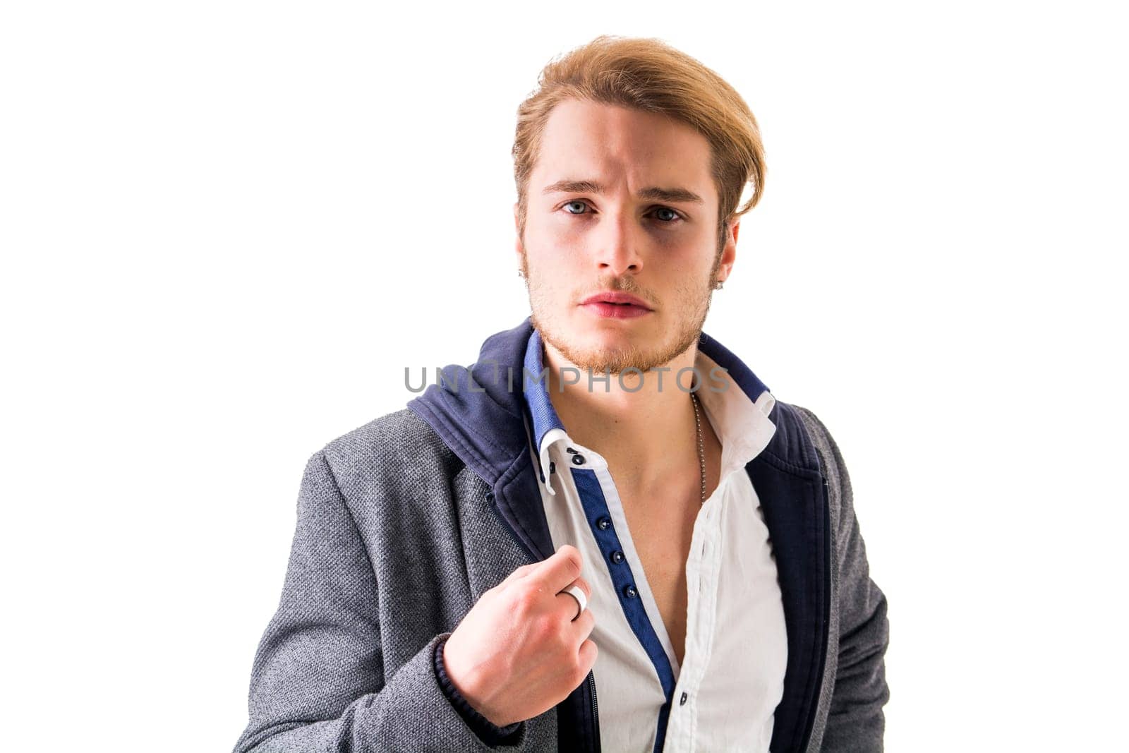 Handsome young man with aggressive expression of challenge, isolated on white background