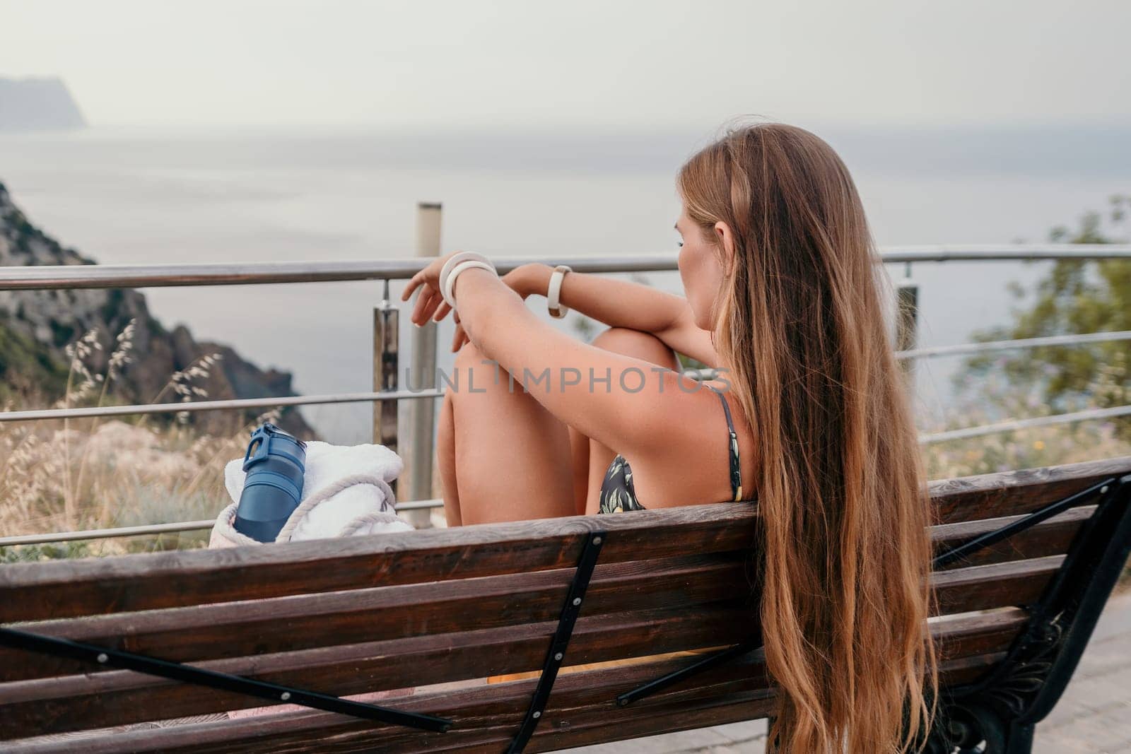 Woman travel sea. Happy tourist taking picture outdoors for memories. Woman traveler looks at the edge of the cliff on the sea bay of mountains, sharing travel adventure journey.