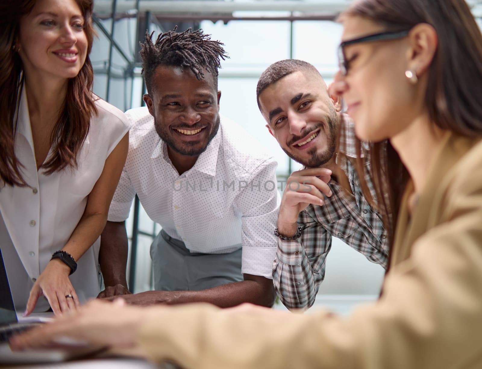 Diverse multinational team having a conversation in a conference room in a creative office.