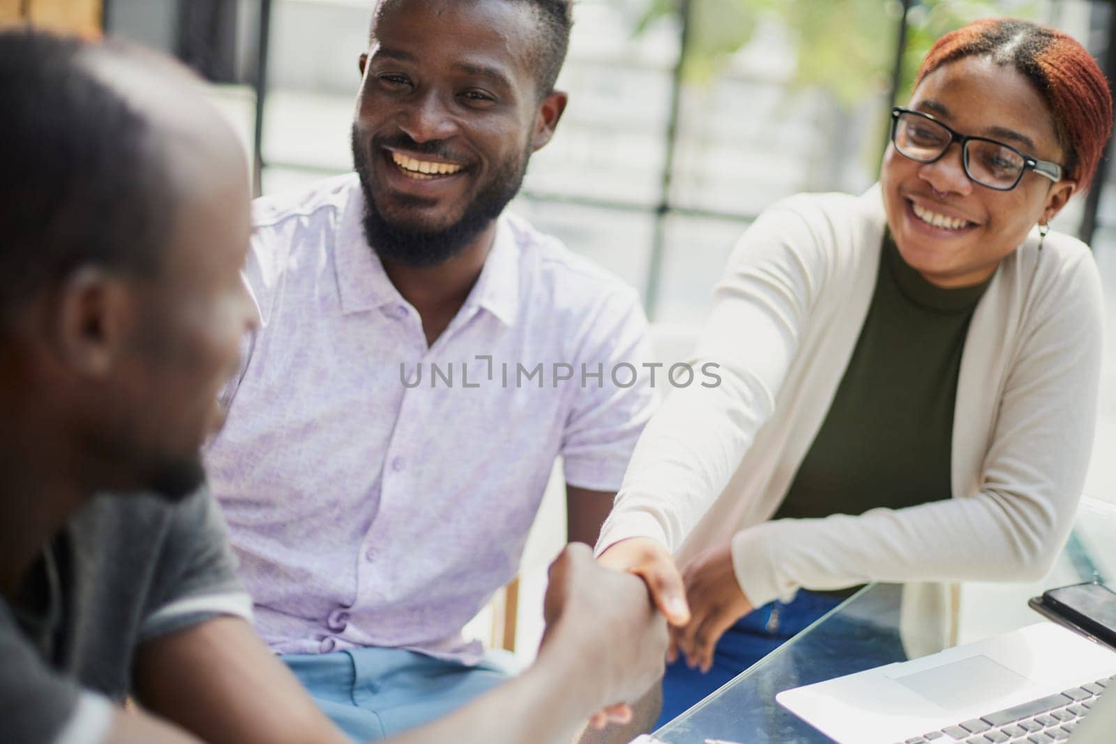 african business people handshaking at modern office by Prosto