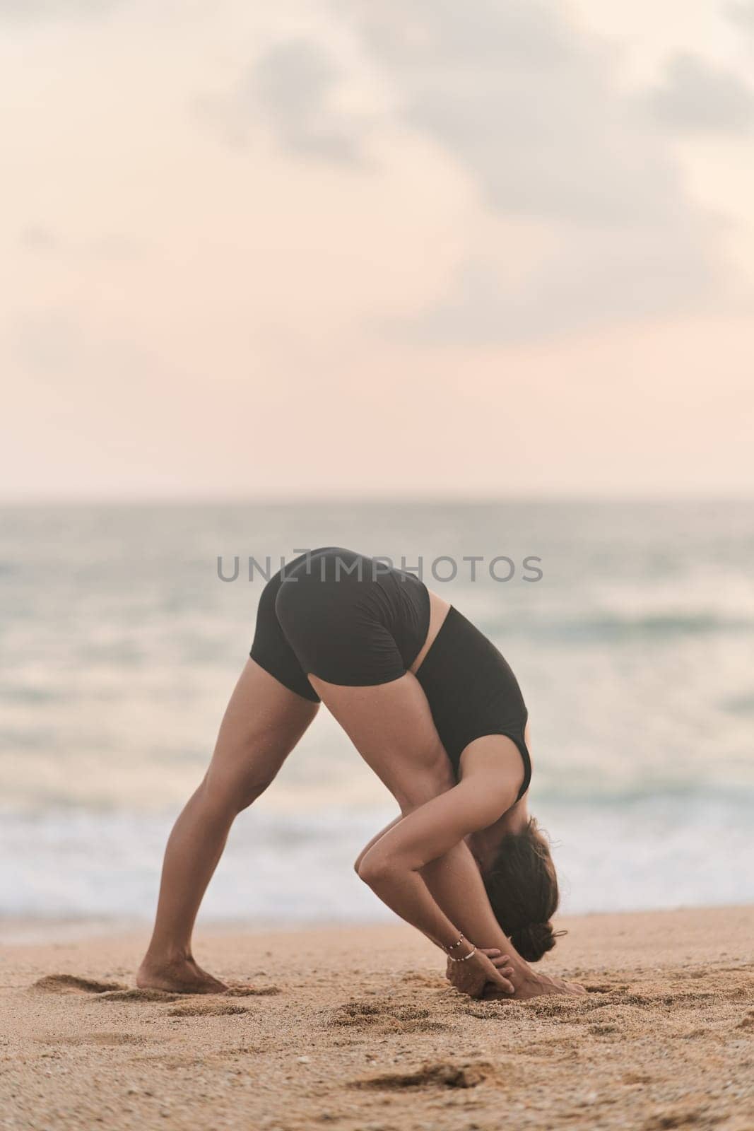 Beautiful girl doing yoga at the beach by driver-s