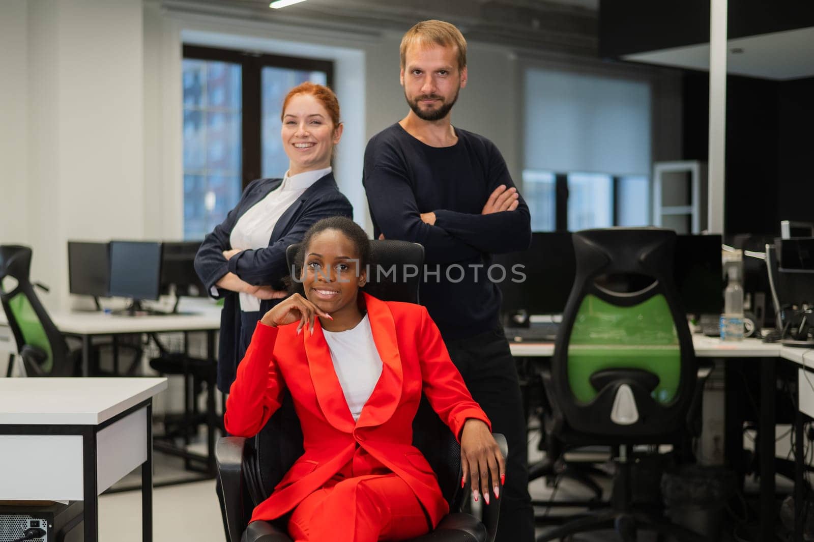 Caucasian redhead woman, bearded caucasian man and african american young woman in office