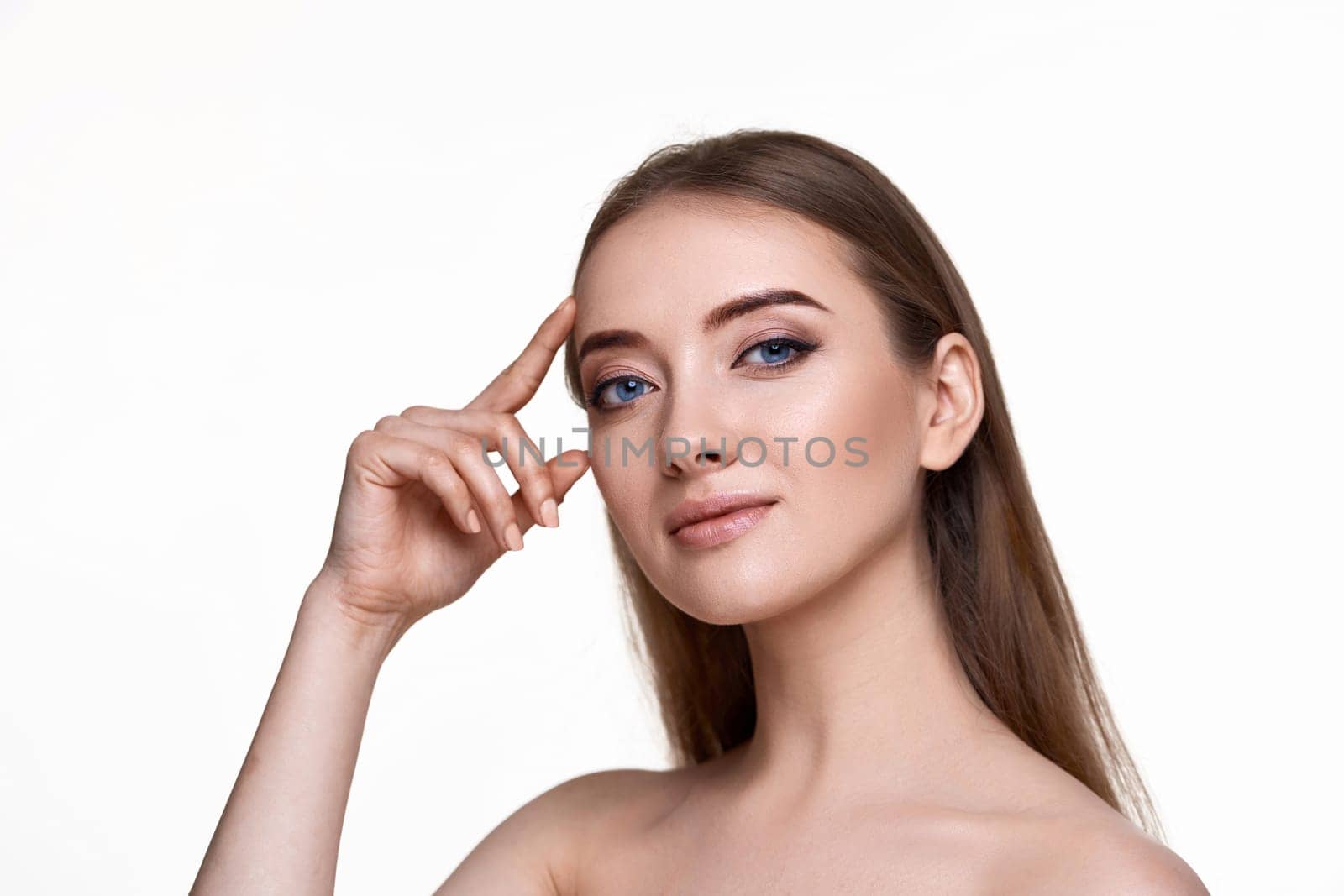 Beautiful young woman with perfect skin check the line of eyebrows and eyes without wrinkles on white background. Face lifting concept.