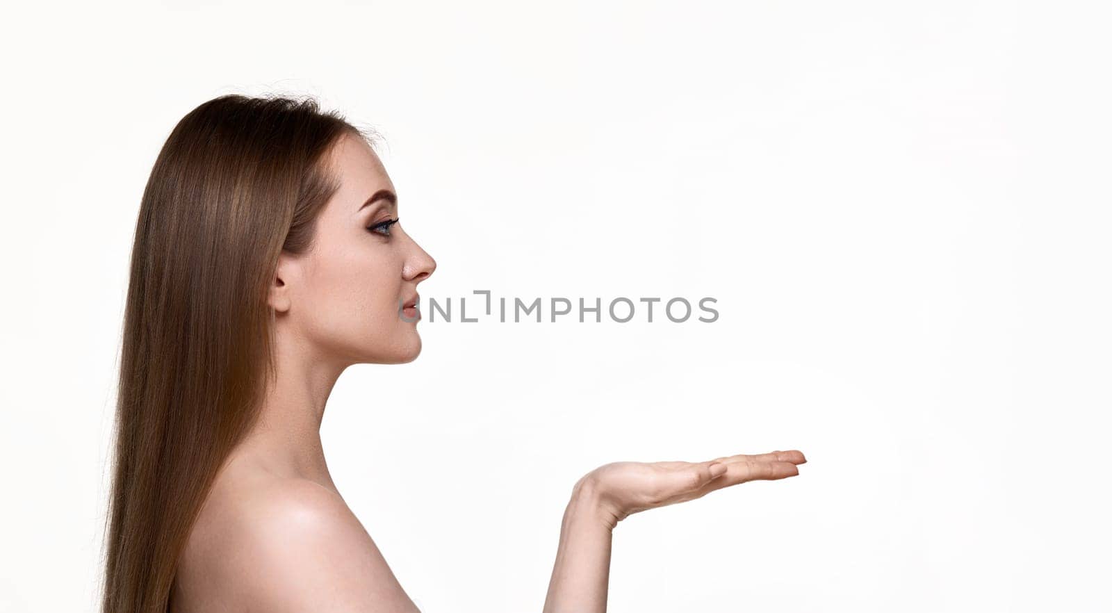 pretty young woman holding on open arm copy space isolated on white background. facial therapy