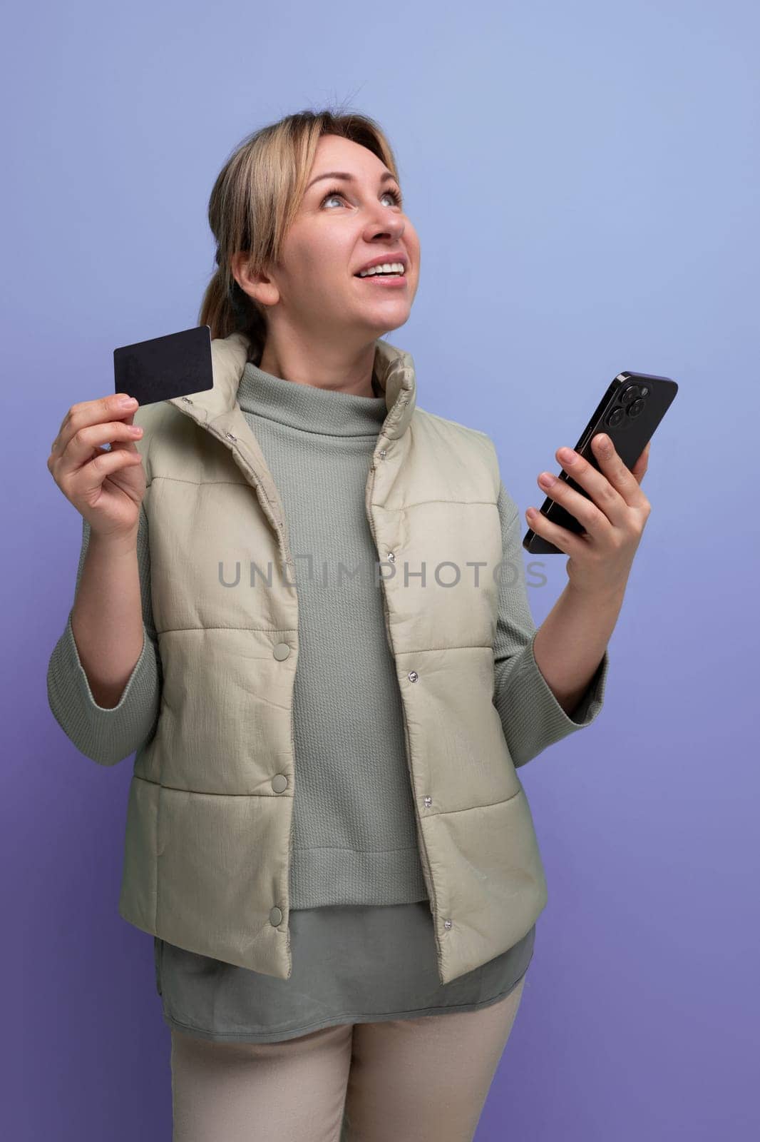 young blond hair woman uses app on smartphone to pay for purchases from card.