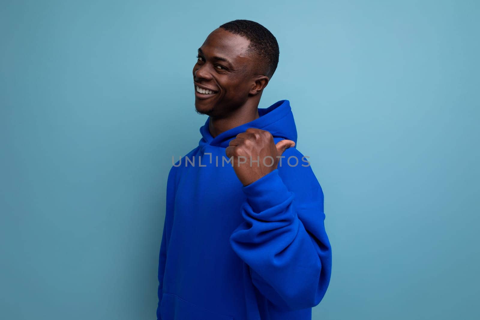 authentic ethnic young african man in stylish hoodie on blue background by TRMK