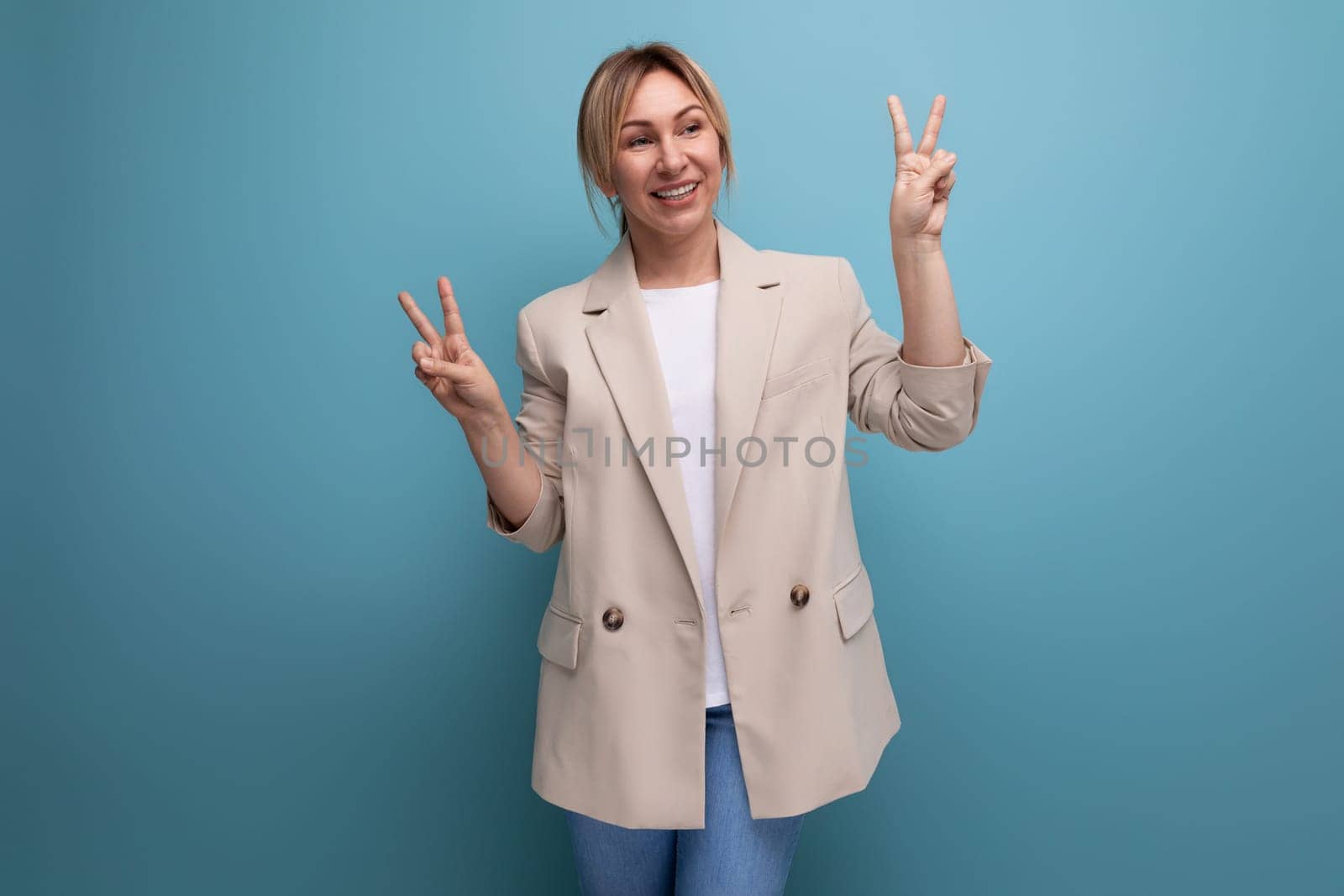 close-up portrait of a positive kind blonde young woman in a stylish elegant look in the studio with copy space by TRMK
