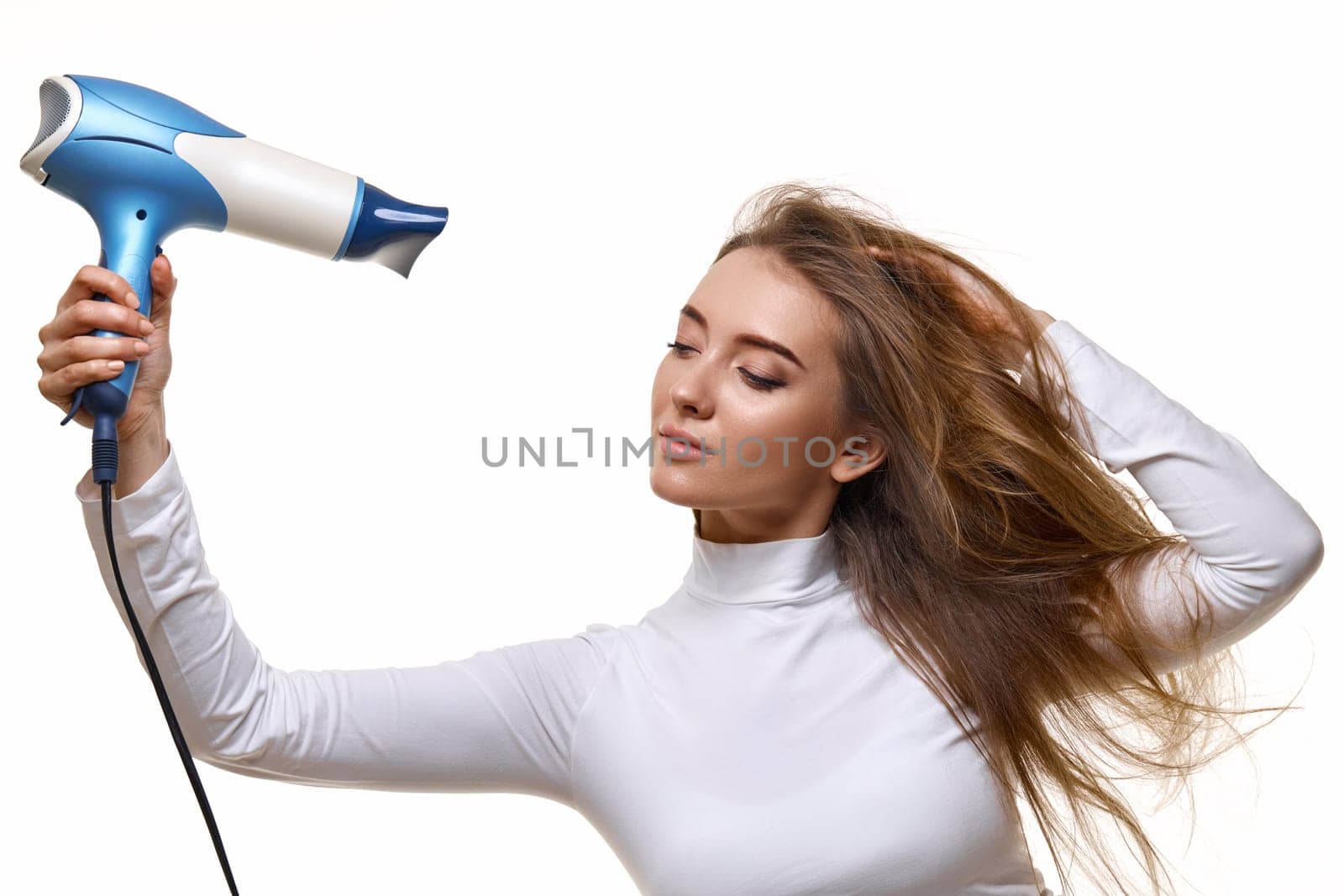 beautiful young woman drying strong healthy hair with dryer i isolated on white background