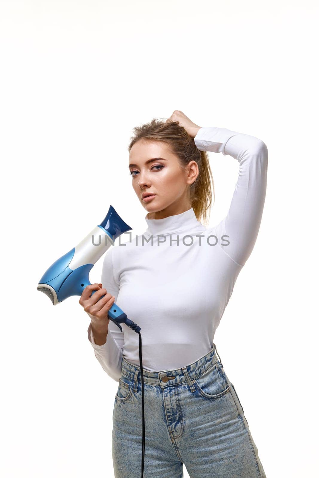 Portrait of attractive cheerful girl drying long hair isolated on white background