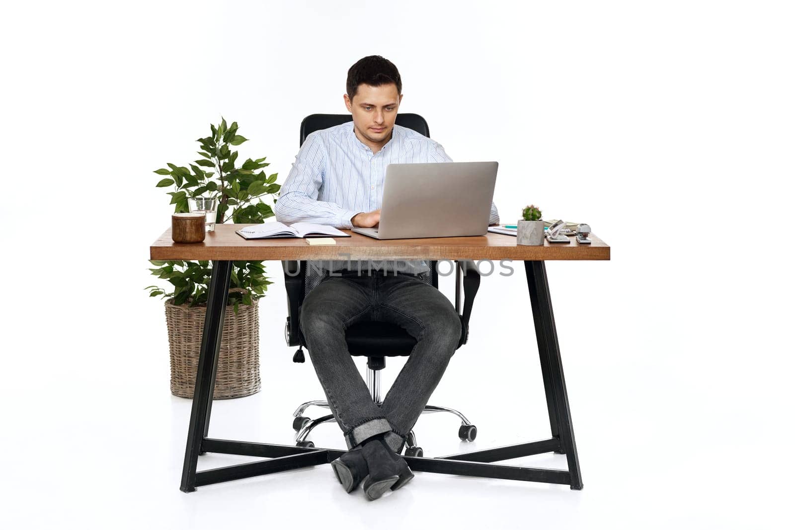 young man using laptop computer for online work at table on white background