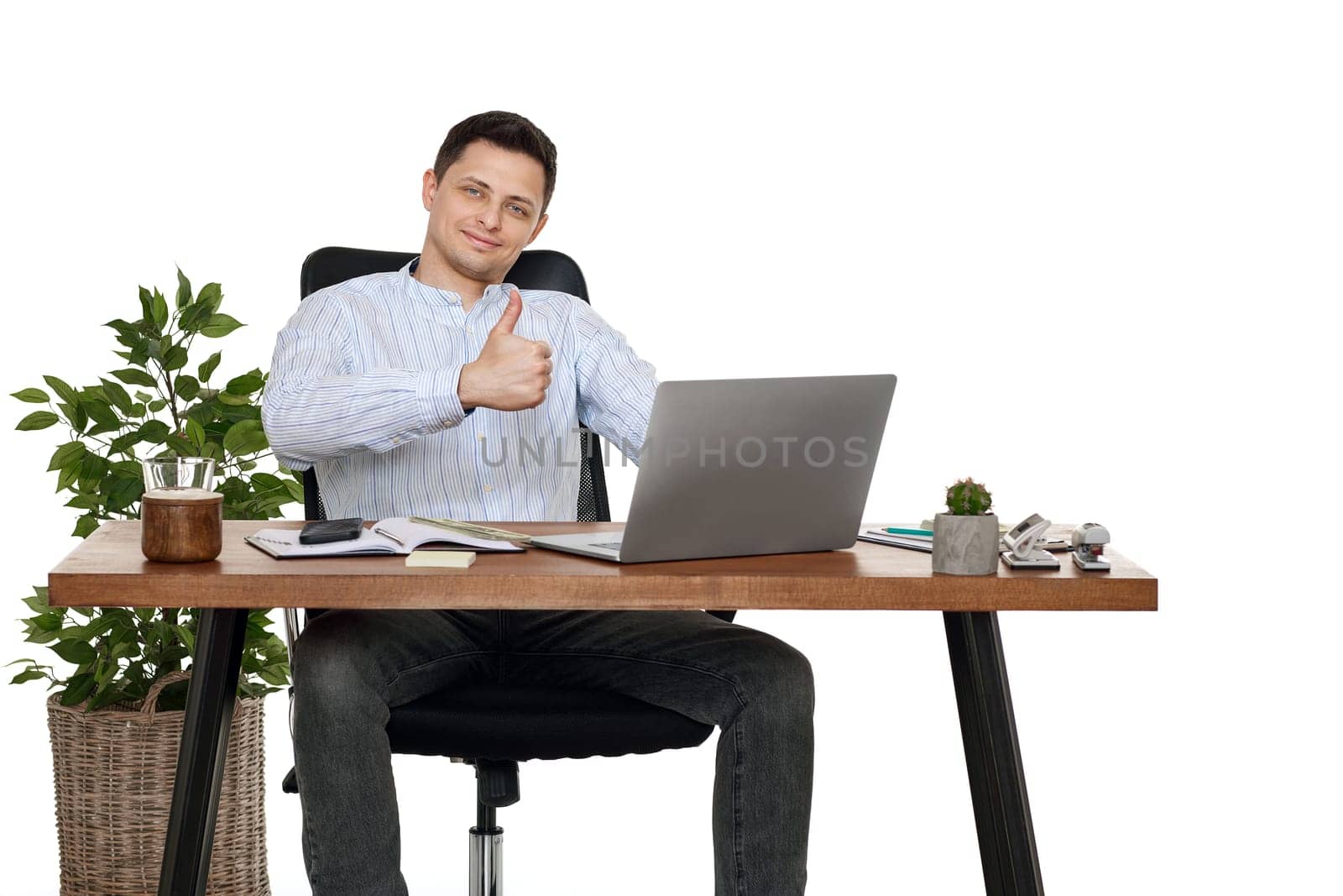 young happy businessman sitting at desk working on laptop pc computer and showing Ok gesture
