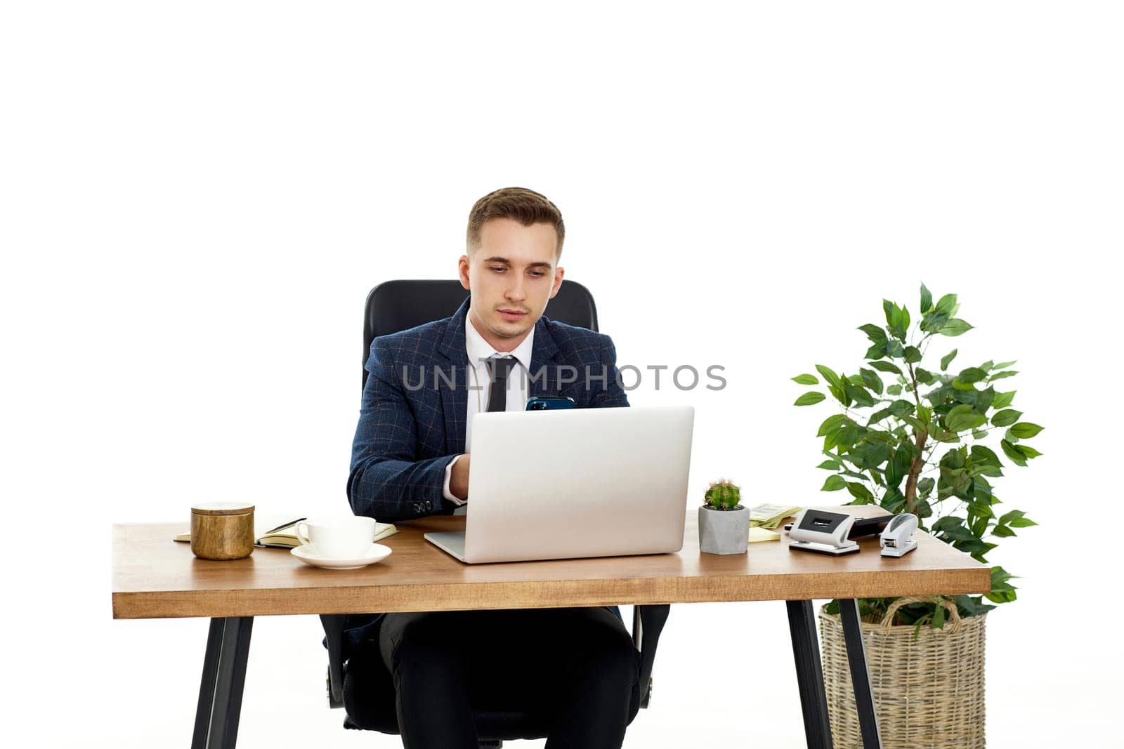 young man using laptop computer for online work at table on white background