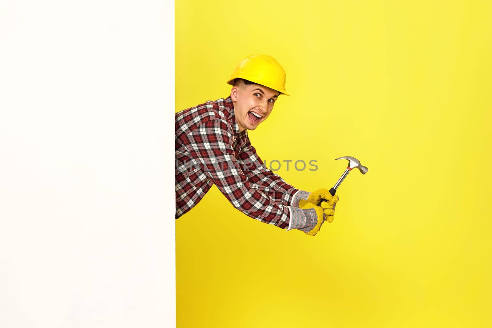 professional builder in work clothes in helmet holding hammer. copy space for text