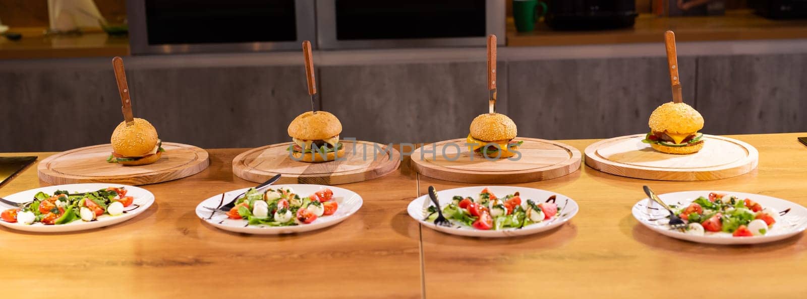 Beef burgers and salad on wooden table. Fat unhealthy food close-up by Satura86