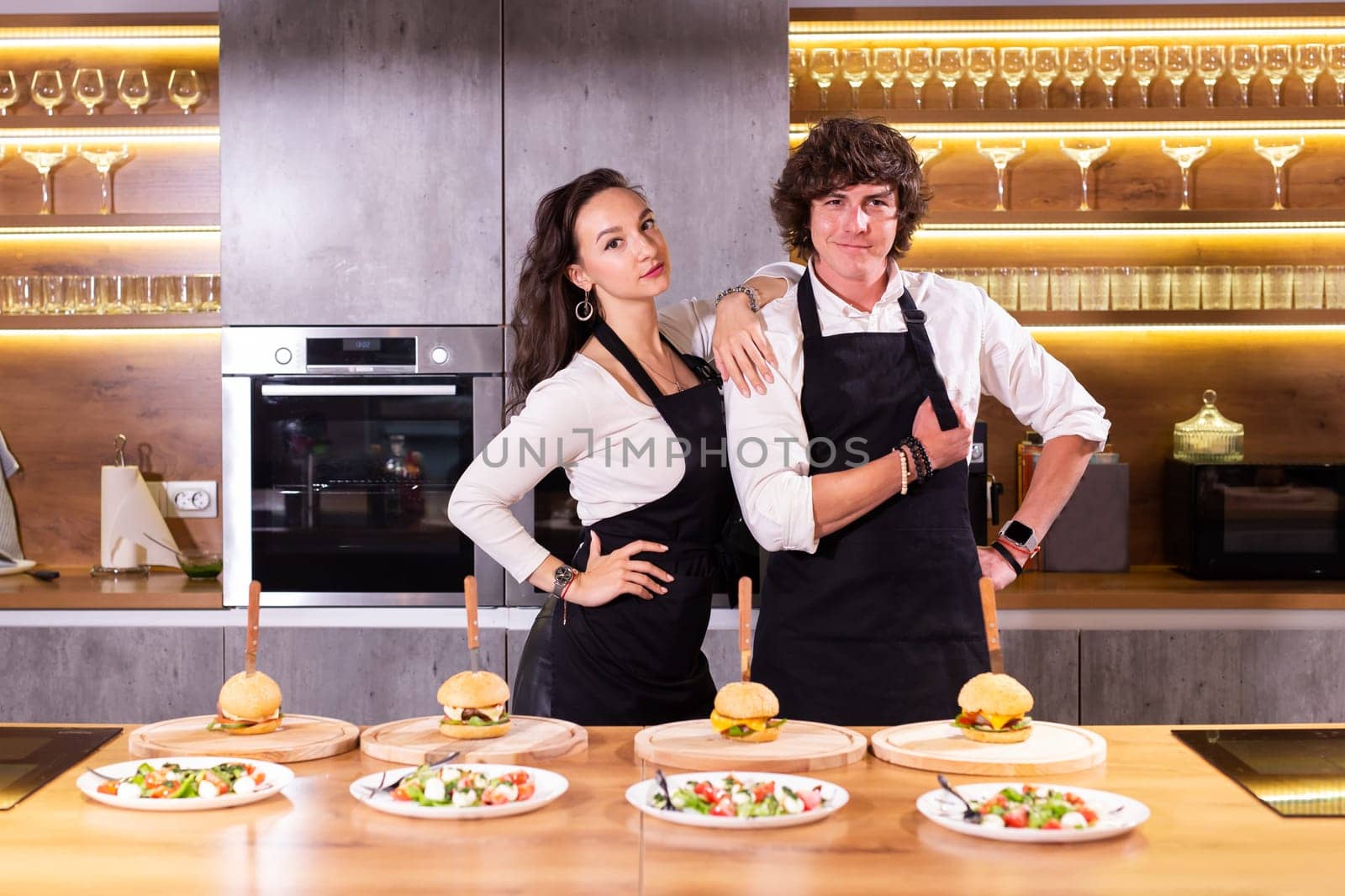 Funny chef and his colleague standing at kitchen with dishes - food and restaurant concept by Satura86