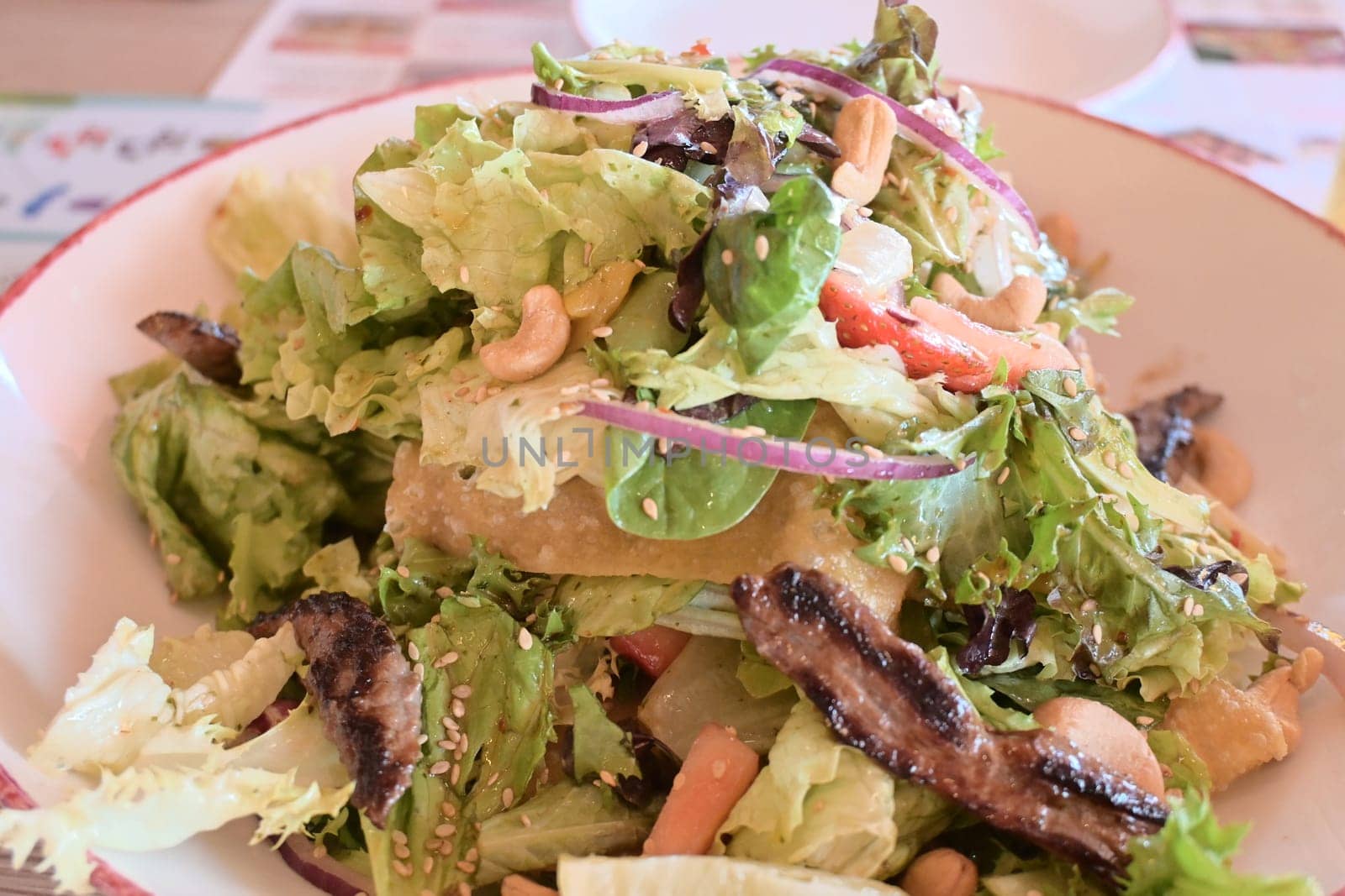 Green vegan salad from green leaves mix and vegetables. Top view on gray stone table.