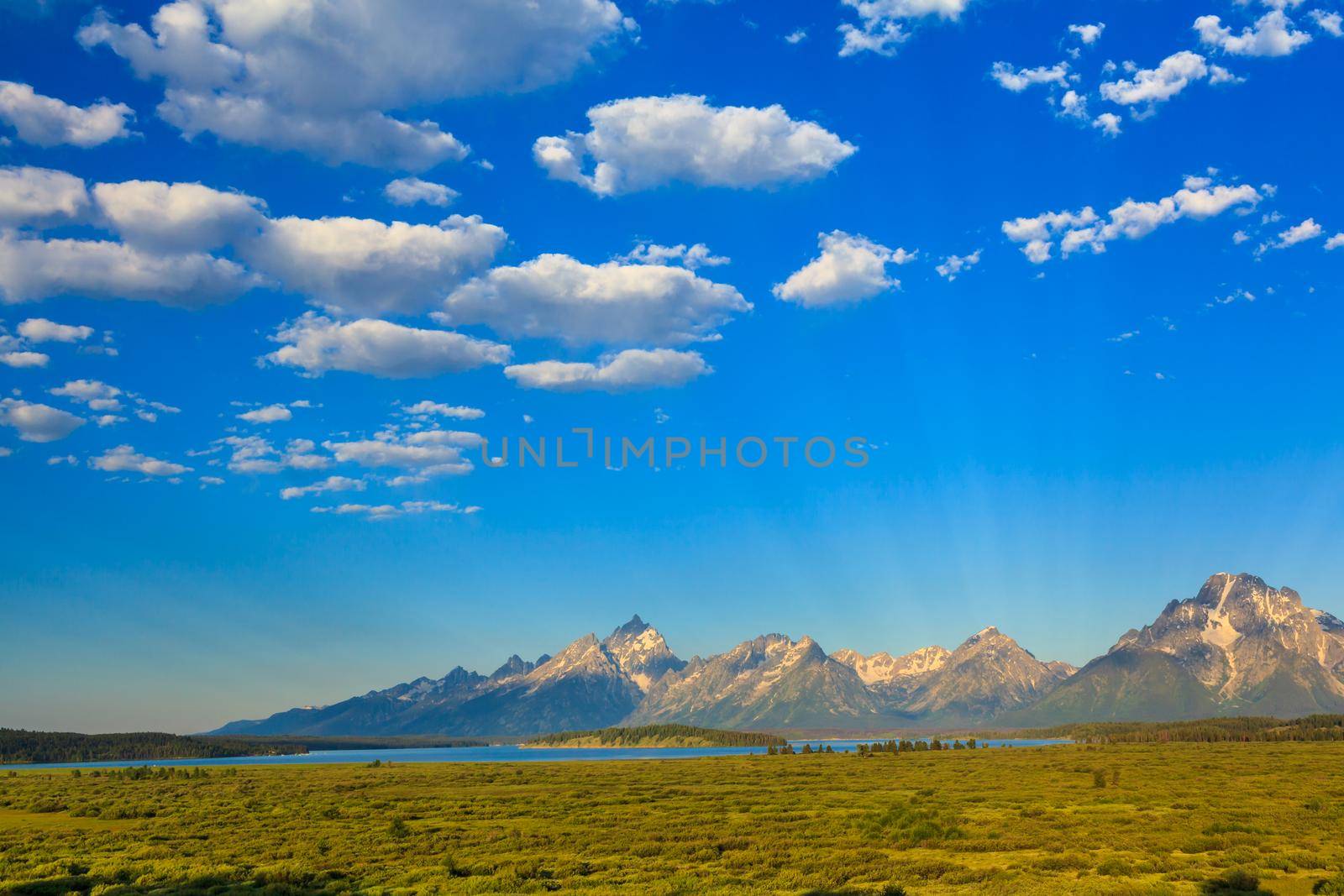 Jackson Lake in front of Teton Range in Grand Teton National Park.  Taken in early morning, blue sky with spotty cloud