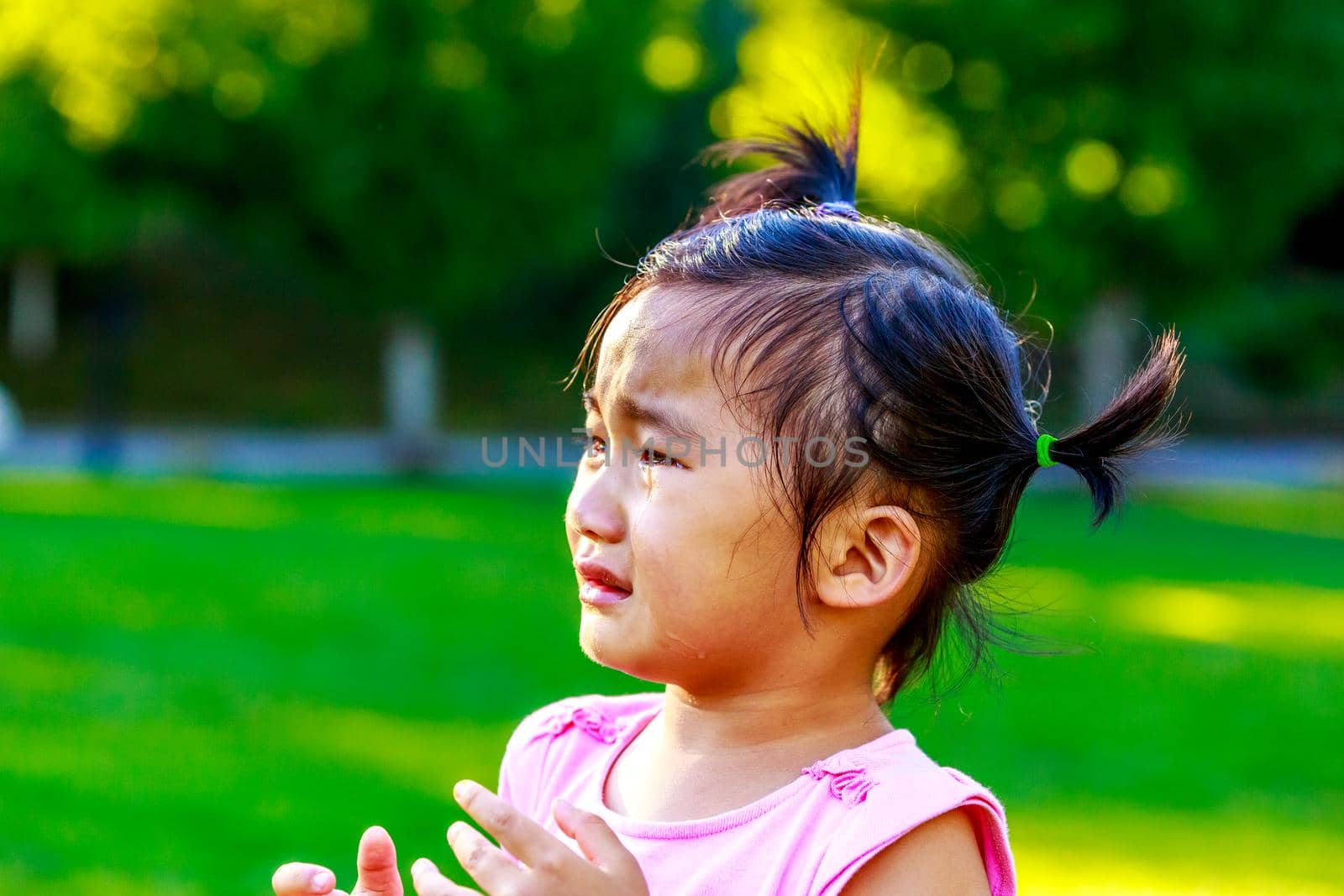 Adorable girl upset and cry in the park