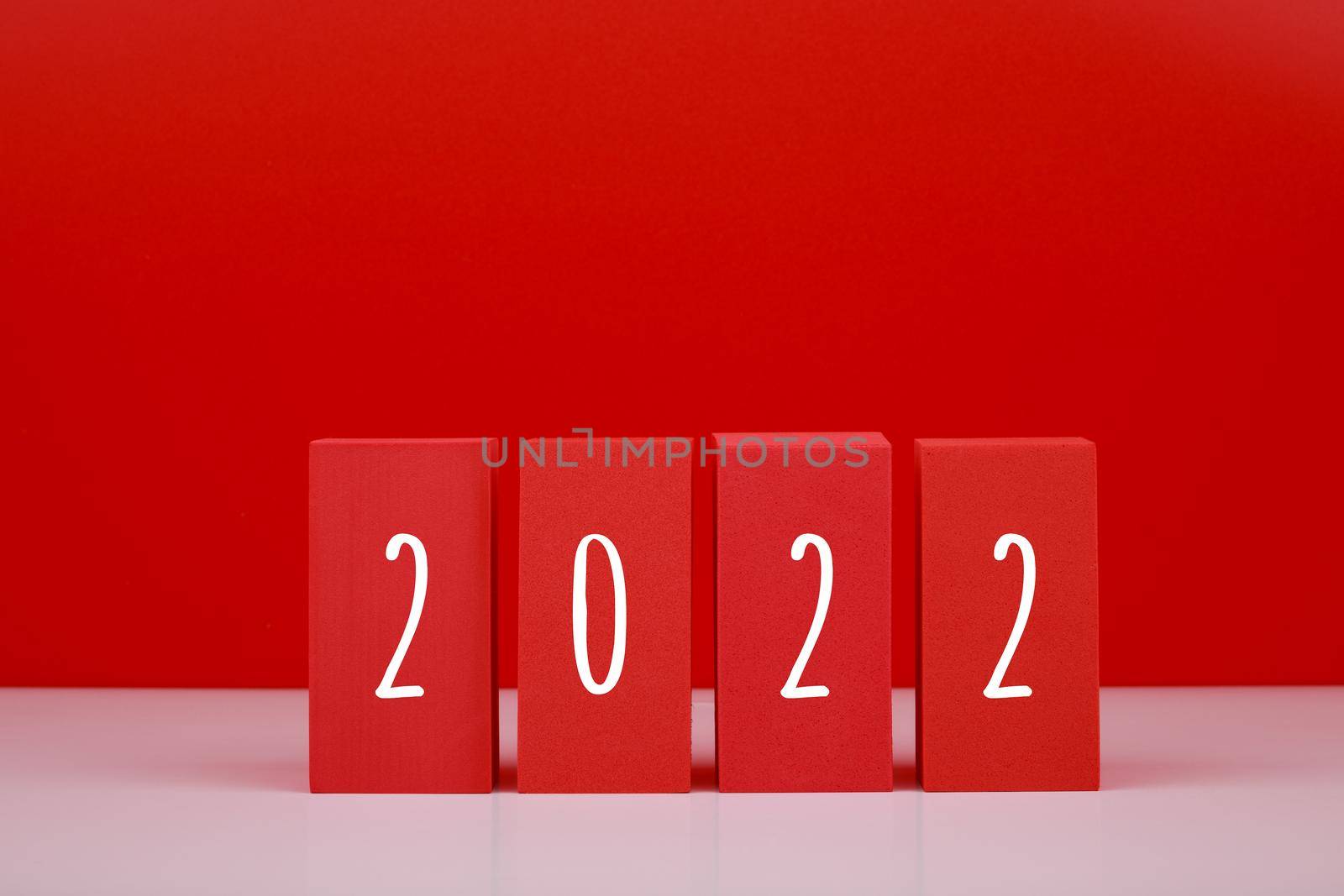 2022 Happy New Year red minimal trendy concept. Modern composition with red blocks with written 2022 numbers against red background with copy space. 