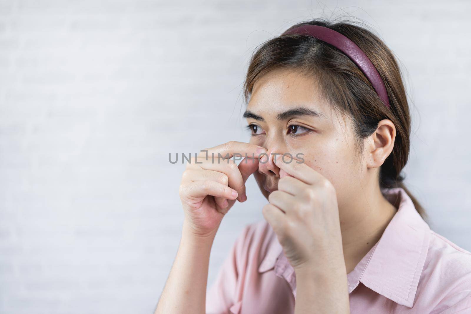 Young woman with acne problem on gray background by Wmpix