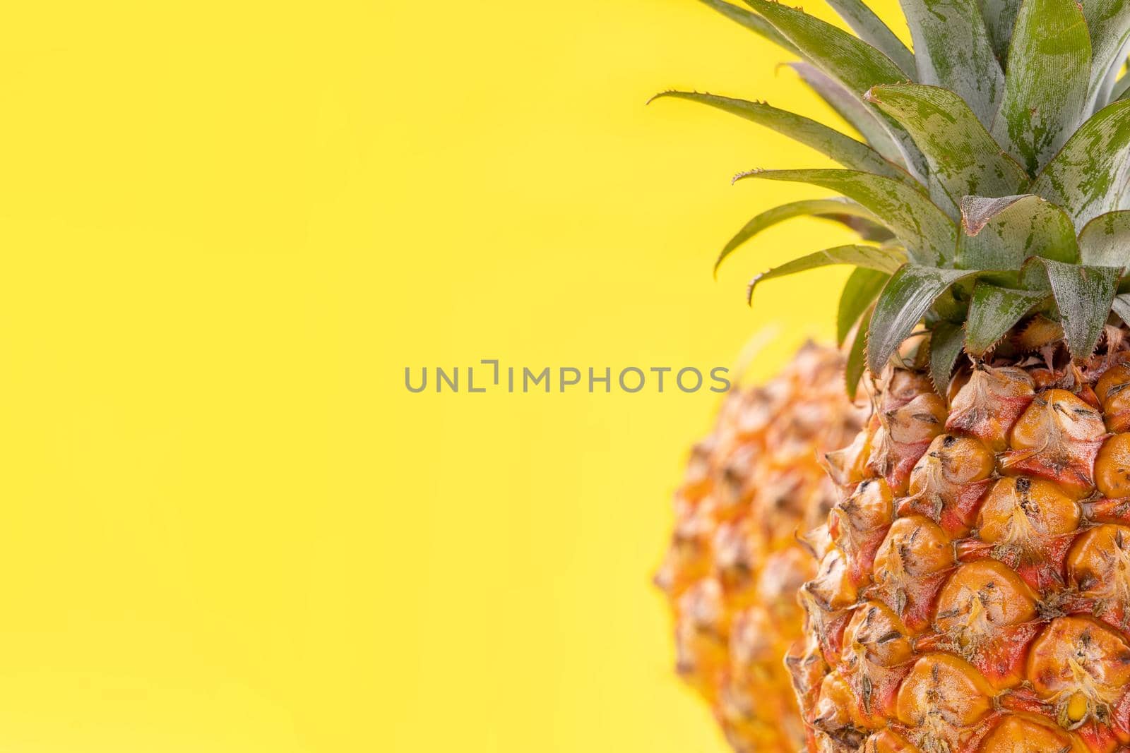 Beautiful fresh pineapple isolated on bright yellow background, summer seasonal fruit design idea pattern concept, copy space, close up by ROMIXIMAGE