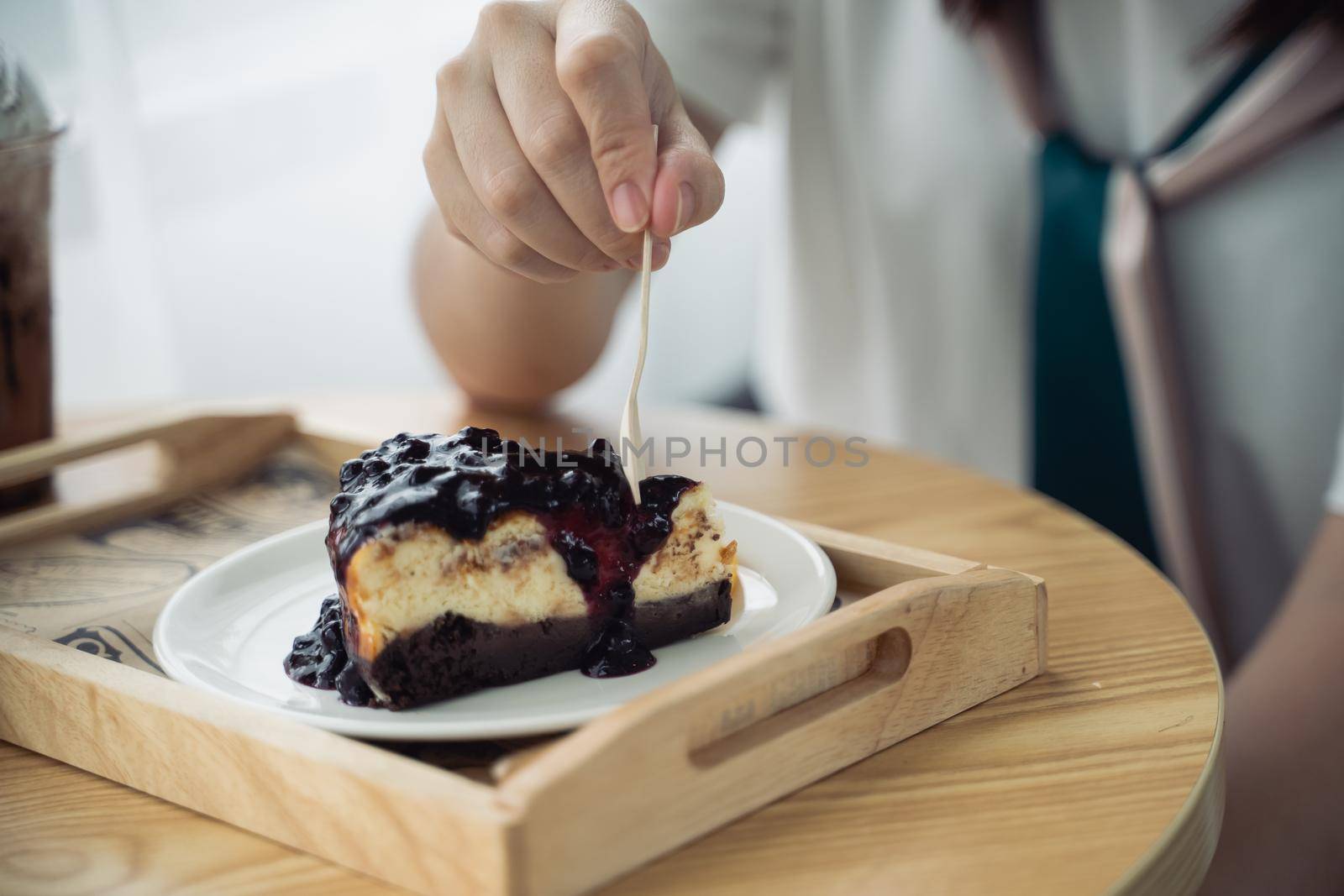 Women eating blueberry cheesecake on the wood table in the cafe