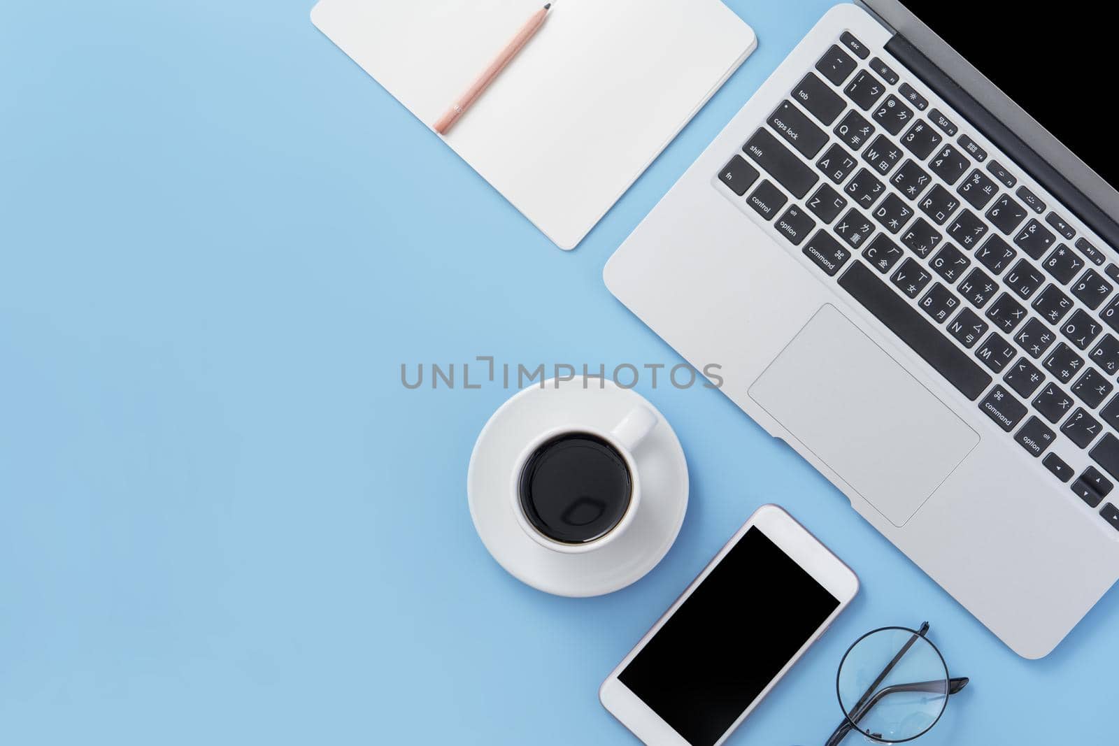 Business concept. Clean bright light blue office table desk, minimal style with laptop coffee and smart phone, copy space, top view, flat lay, mockup